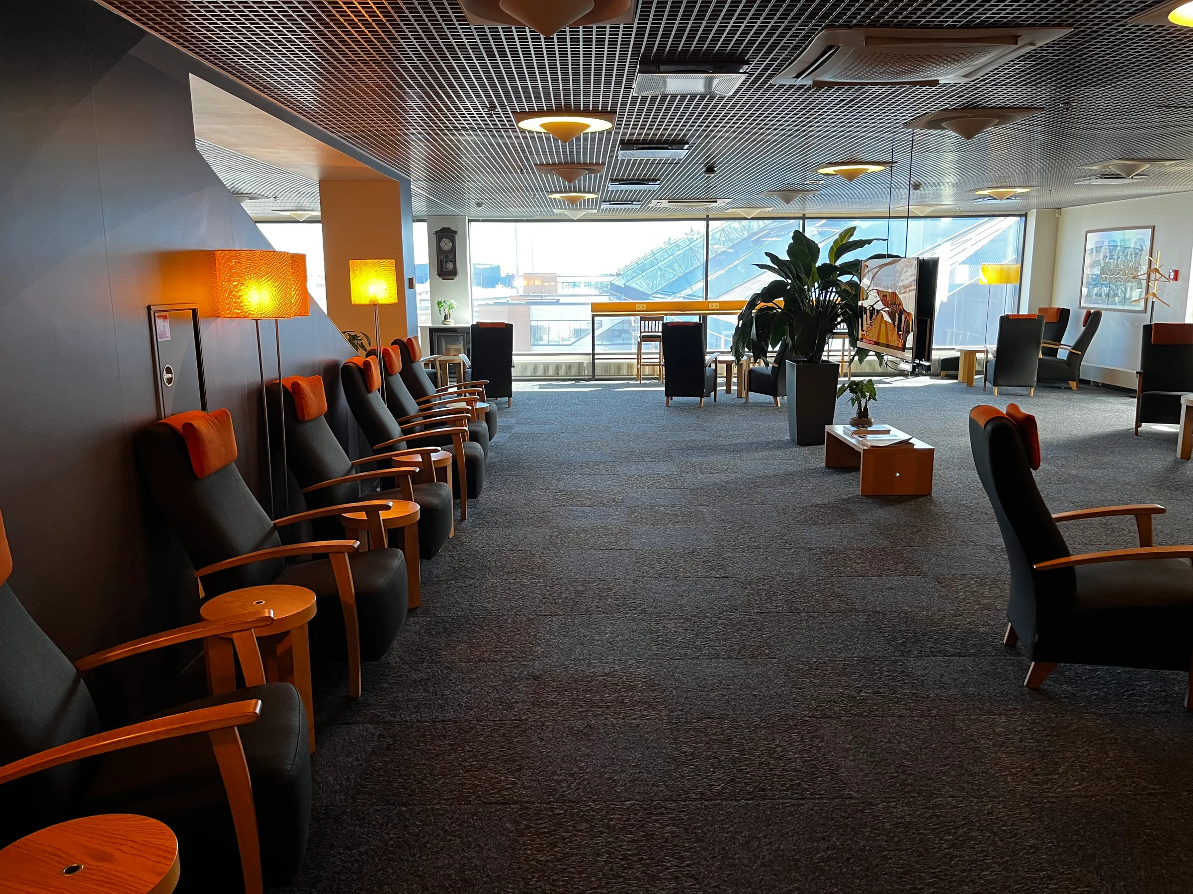 Lounge mit Sesseln und Pflanzen im Flughafen