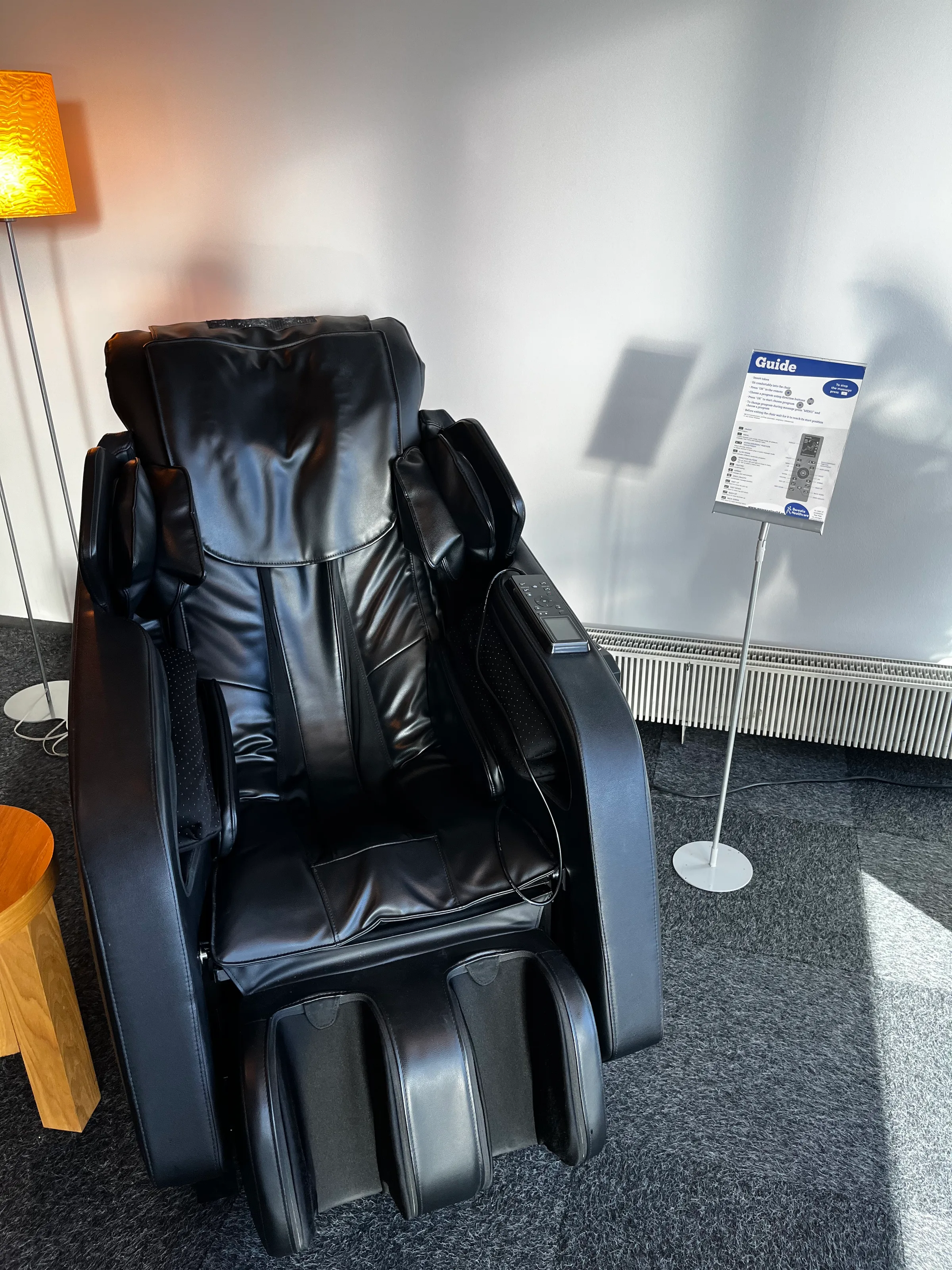Schwarzer Massage-Stuhl im Lounge-Bereich