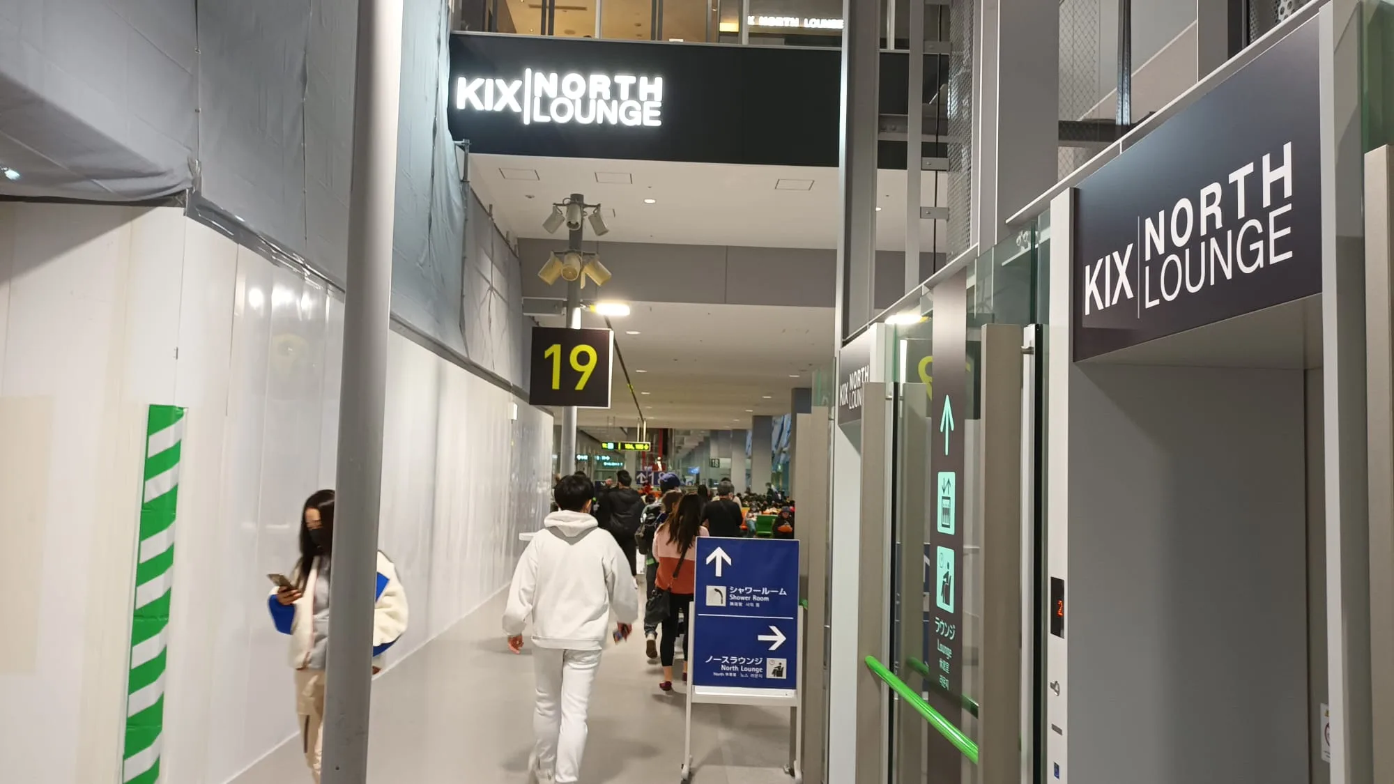 Eingang zum KIX North Lounge mit Schildern und Passagieren