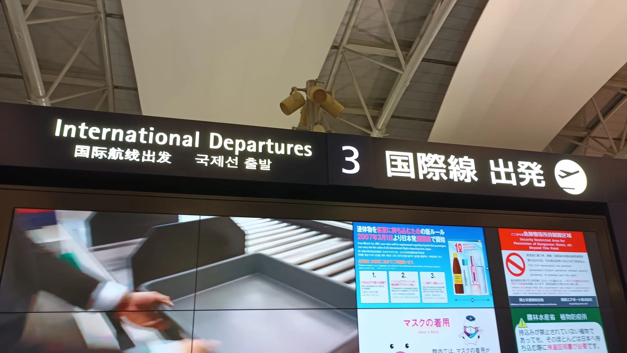 Flughafen-Schild für internationale Abflüge in Japanisch, Englisch und Koreanisch