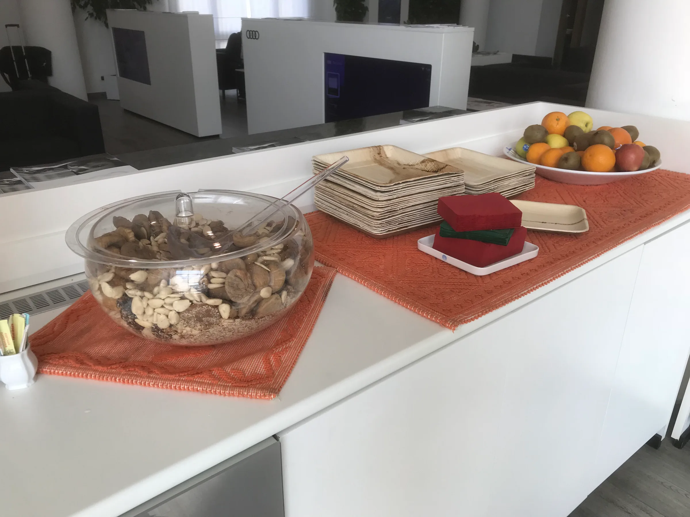 Loungebuffet mit Nüssen und Früchten auf orangefarbenem Tischläufer