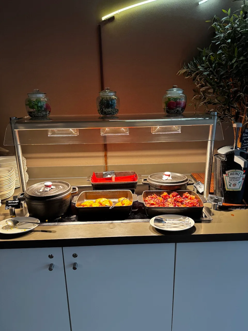 Buffet mit verschiedenen Gerichten und Gewürzbehältern auf dem Tisch