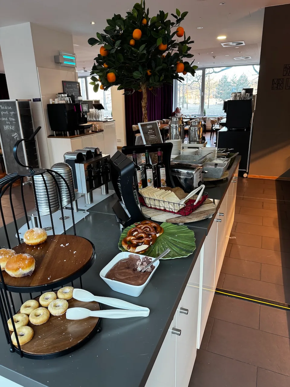 Frühstückstheke mit Donuts, Schokoladencreme und Orangenbaum