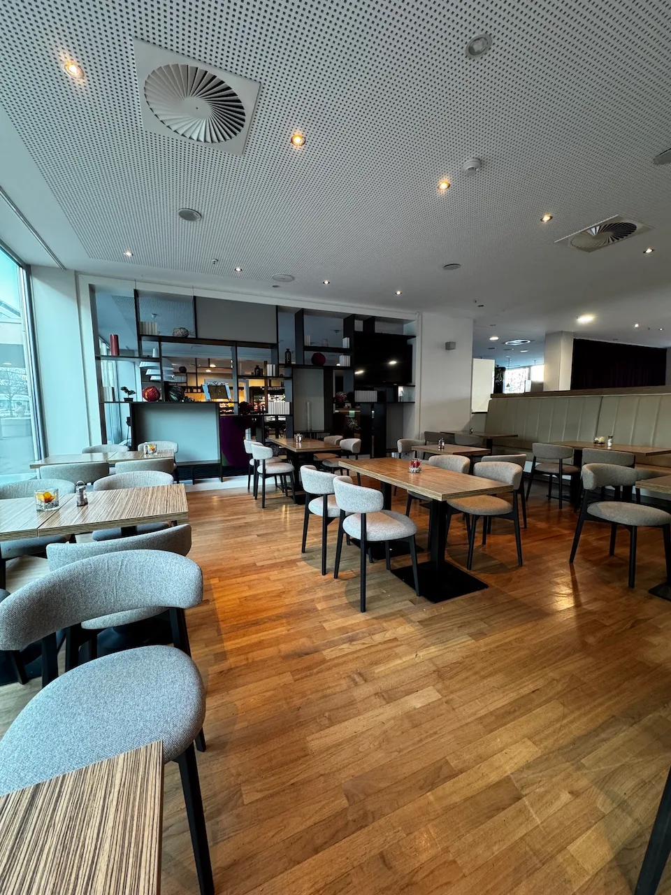 Leerer Restaurantbereich mit Holzboden und modernen Stühlen