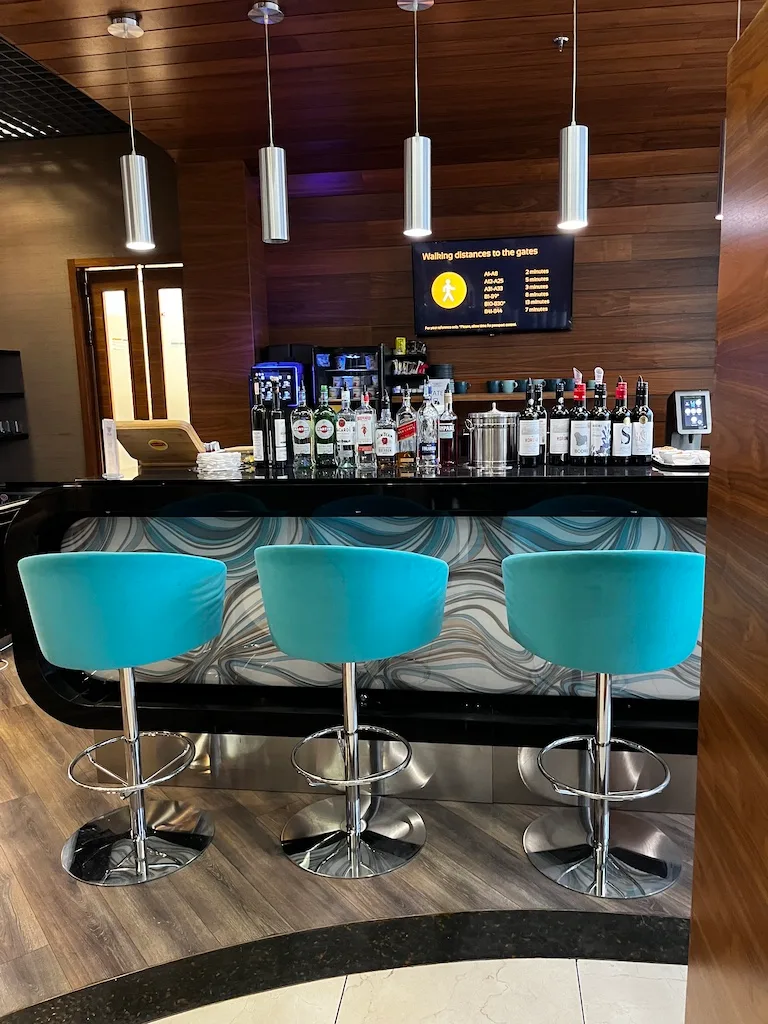 Bar mit blauen Barhockern und Flaschenregal im Hintergrund