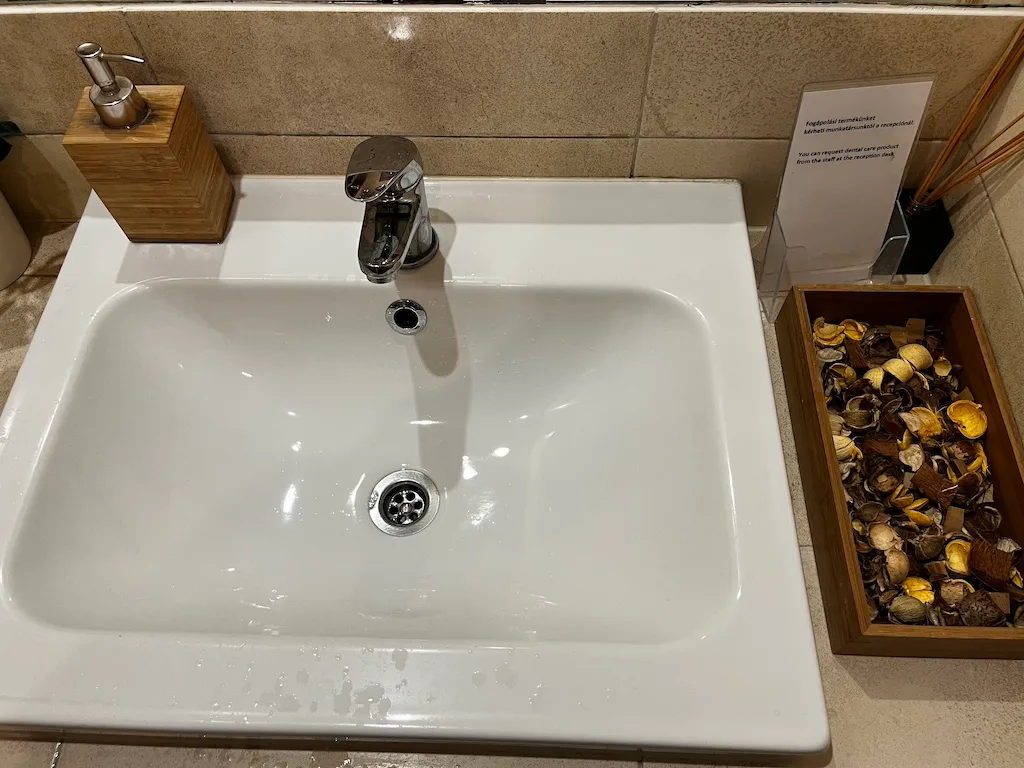 Waschbecken im Flughafenlounge mit Seifenspender und Holzbox