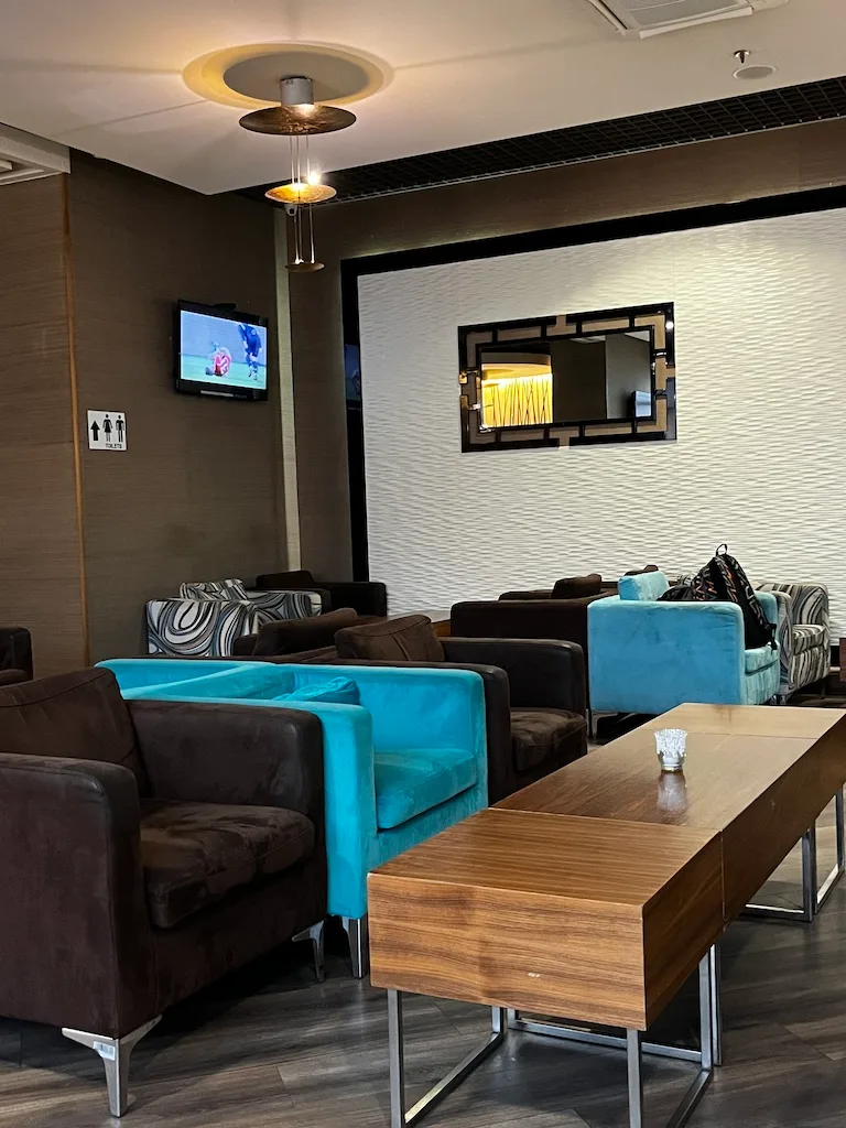 Lounge mit blauen und braunen Sofas und Fernseher an der Wand