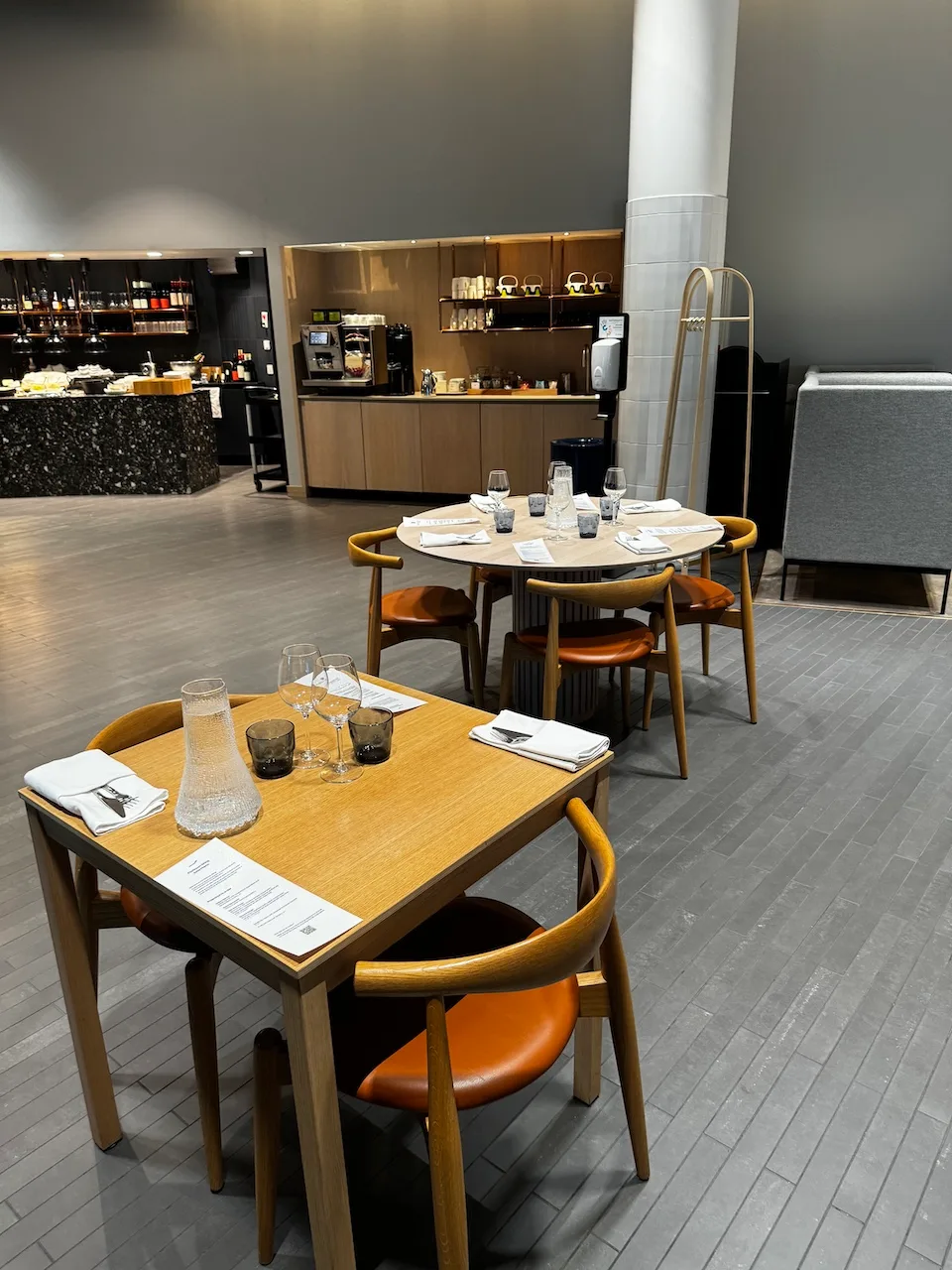 Lounge mit Holztischen und orangefarbenen Stühlen