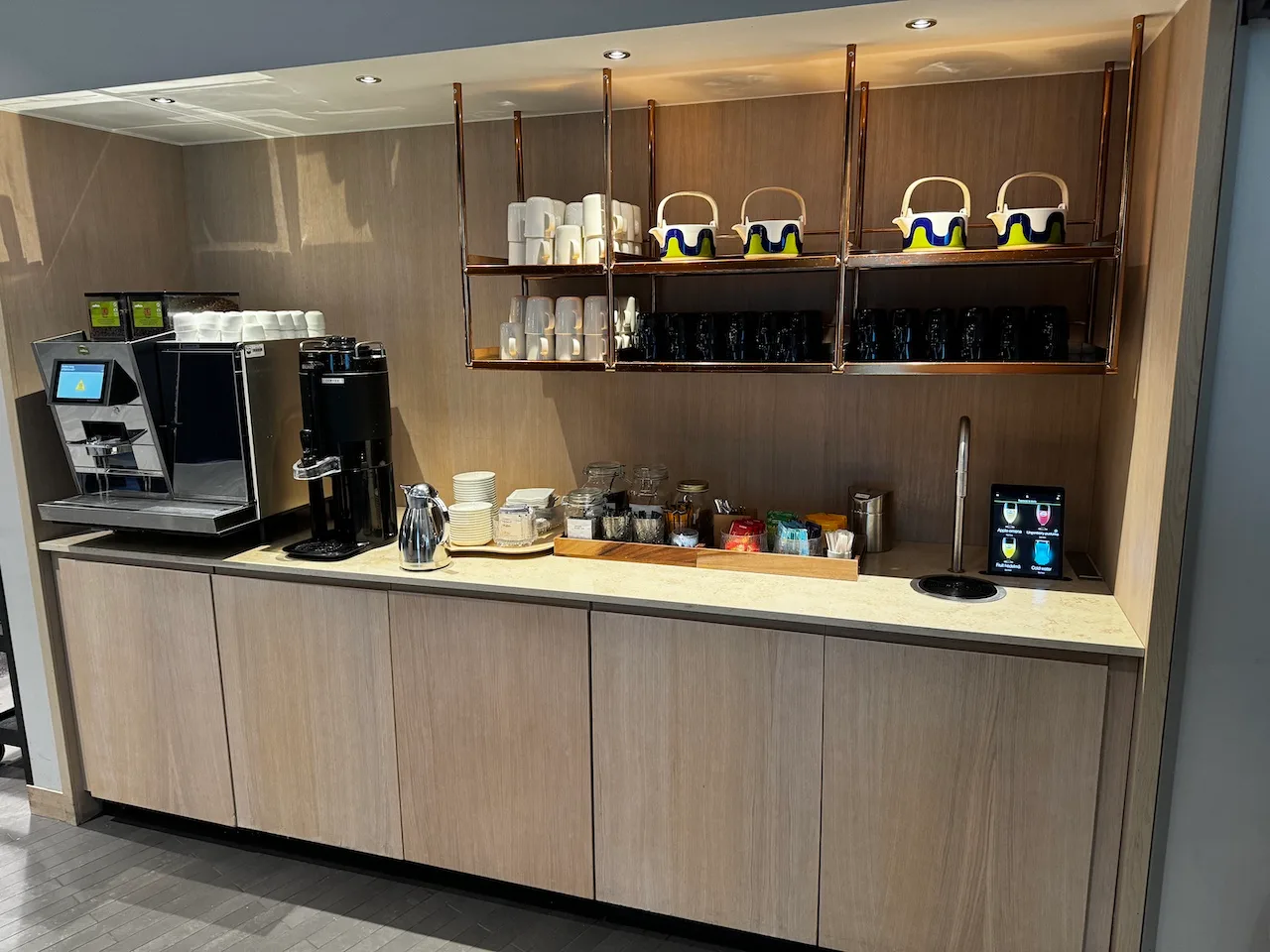 Kaffeebar mit Kaffeemaschine und Geschirr auf Regalen