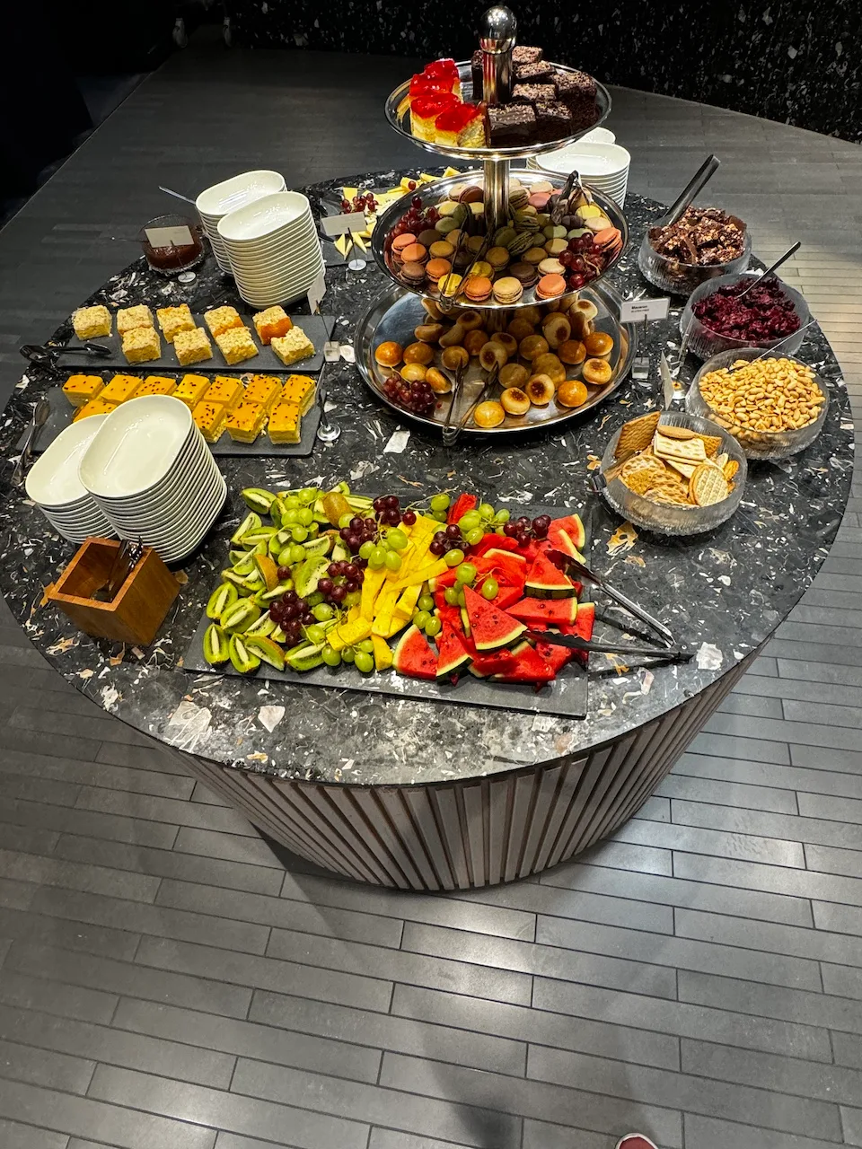 Dreistufiger Fruchtspeicher mit Obst und Käse auf Tisch