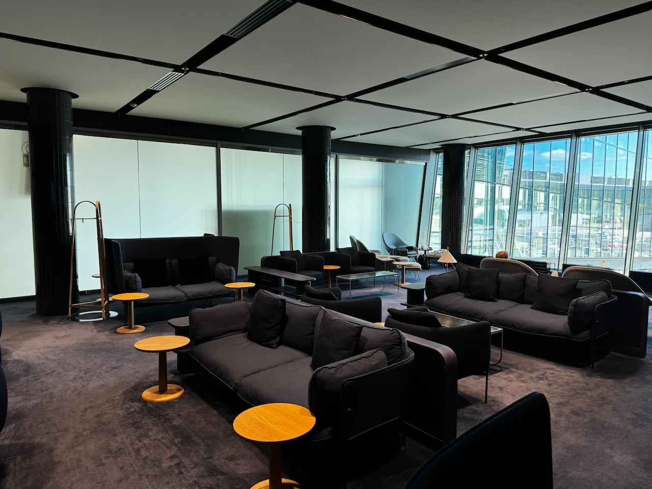 Lounge mit schwarzen Sofas und Holztischen