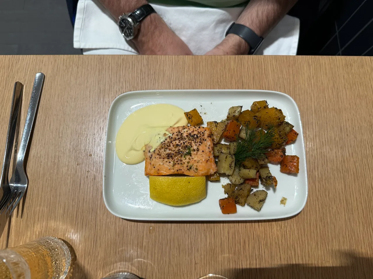 Gefüllter Teller mit Lachs, Kartoffeln und Gemüse auf einem Tisch