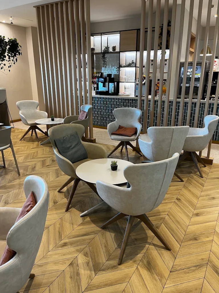 Lounge mit Sesseln und runden Tischen im modernen Design