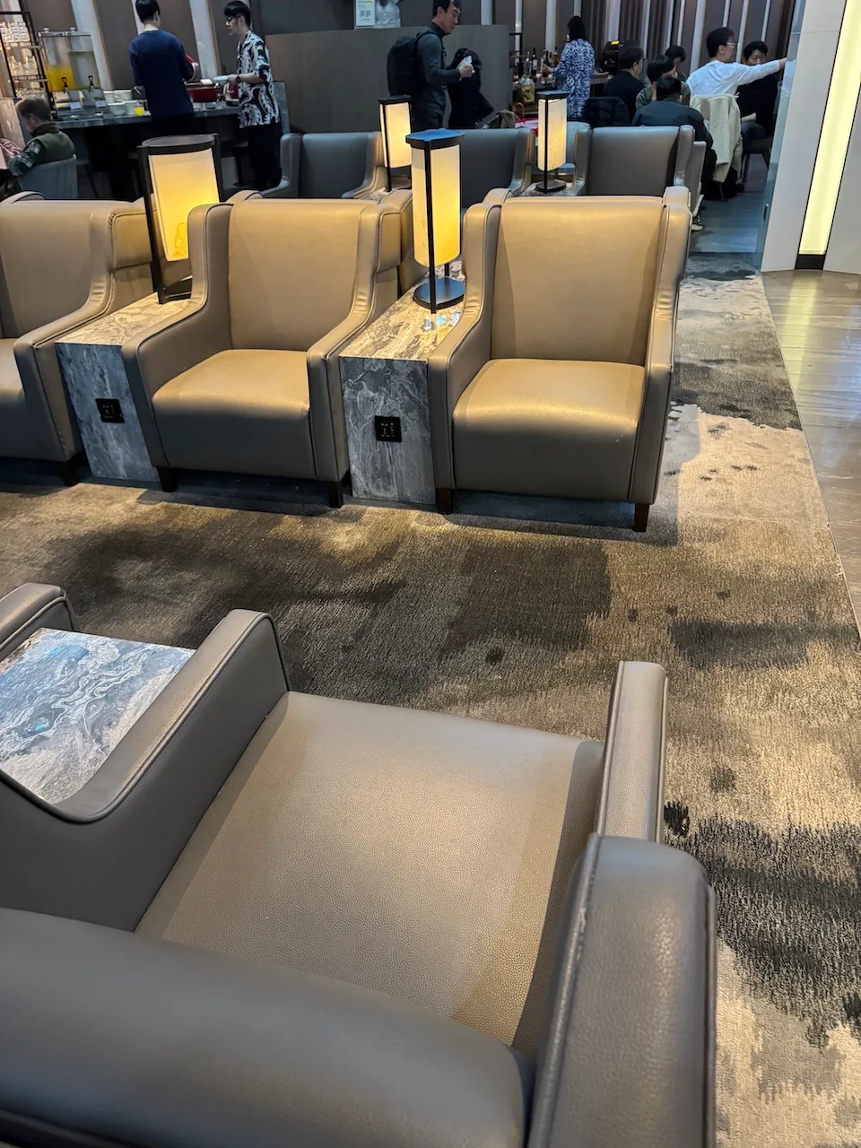 Offener Loungeraum mit Panoramatrennwand zum Terminal