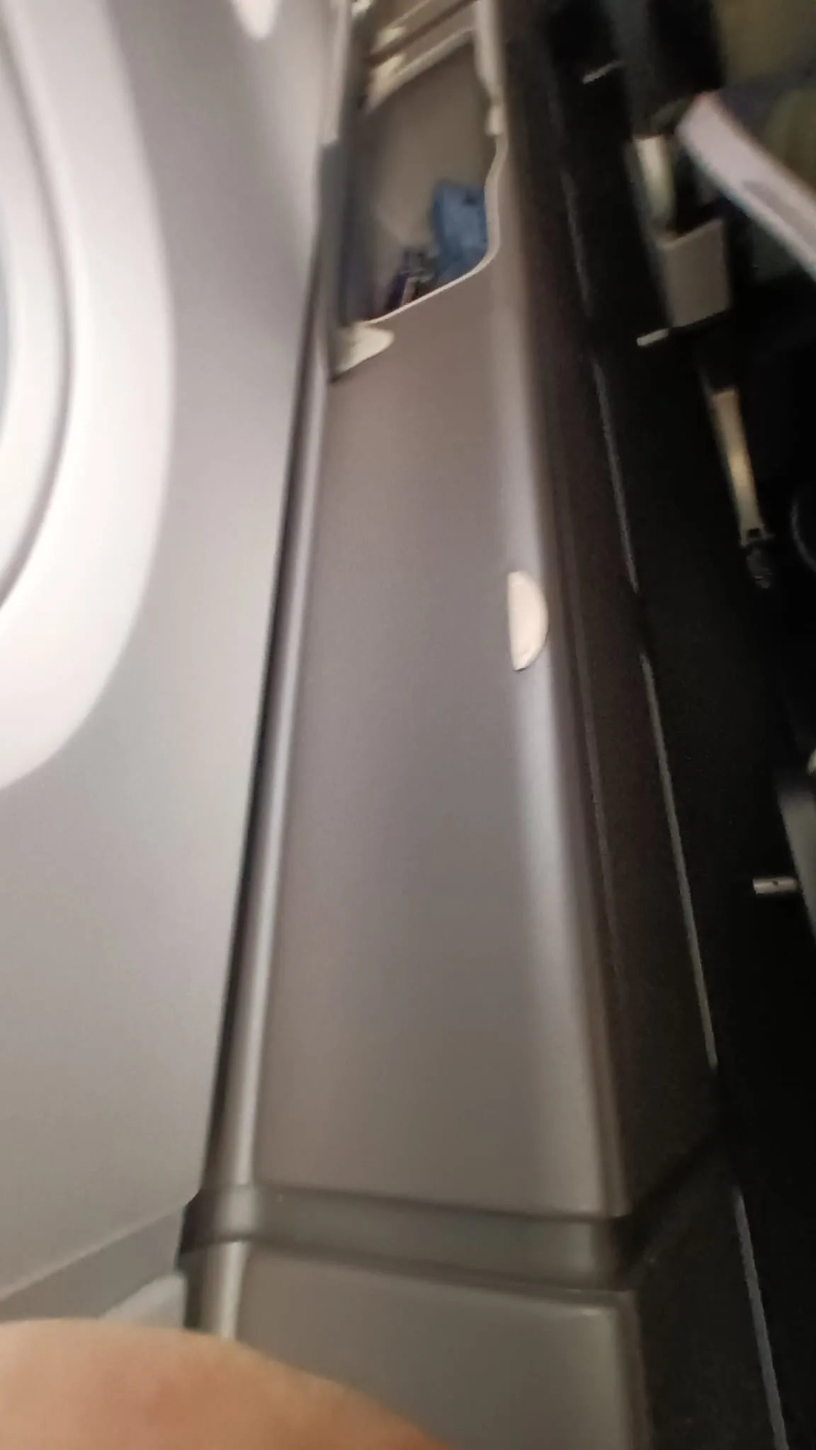 Flugzeugfenster und Armlehne im Premium Economy Sitzbereich
