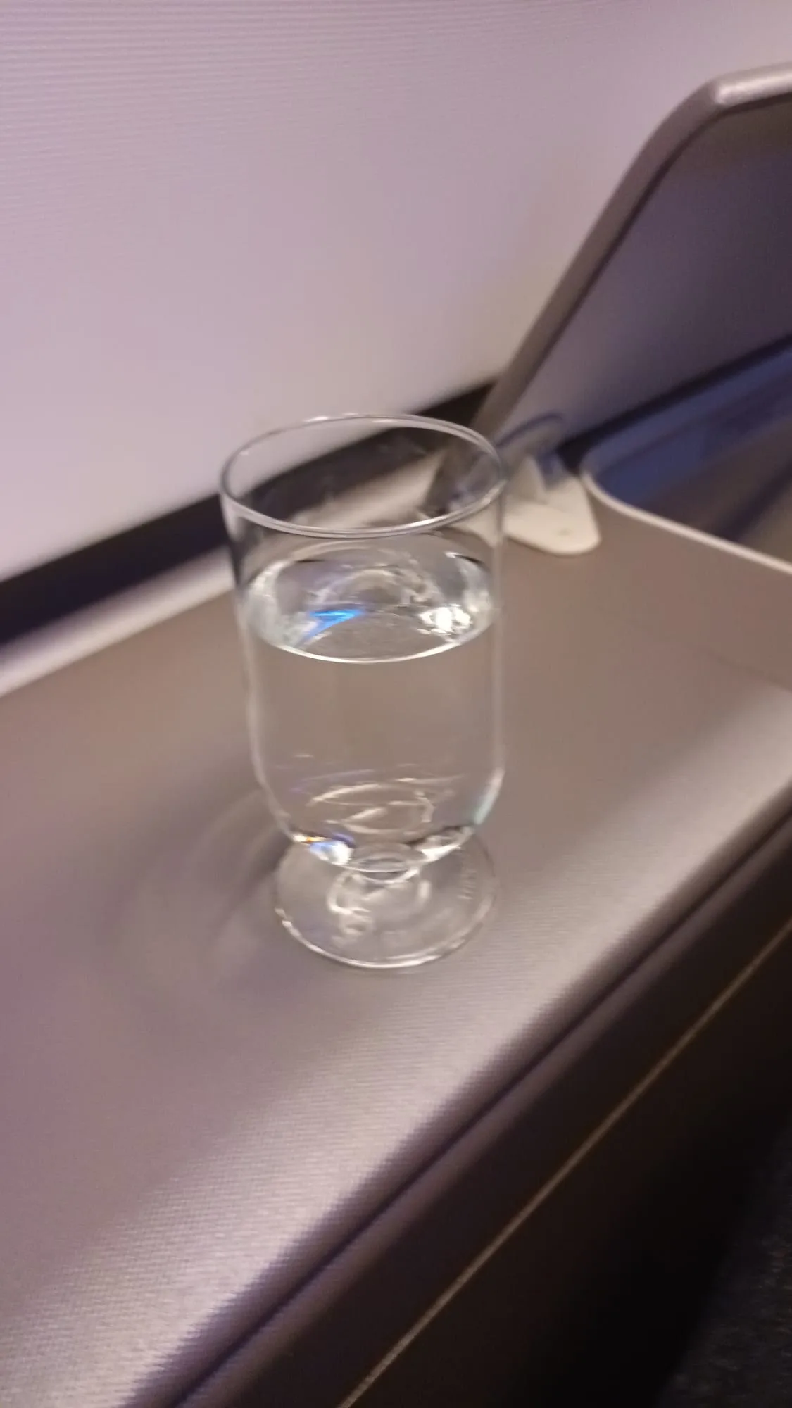 Glas Wasser auf Tisch im Flugzeug