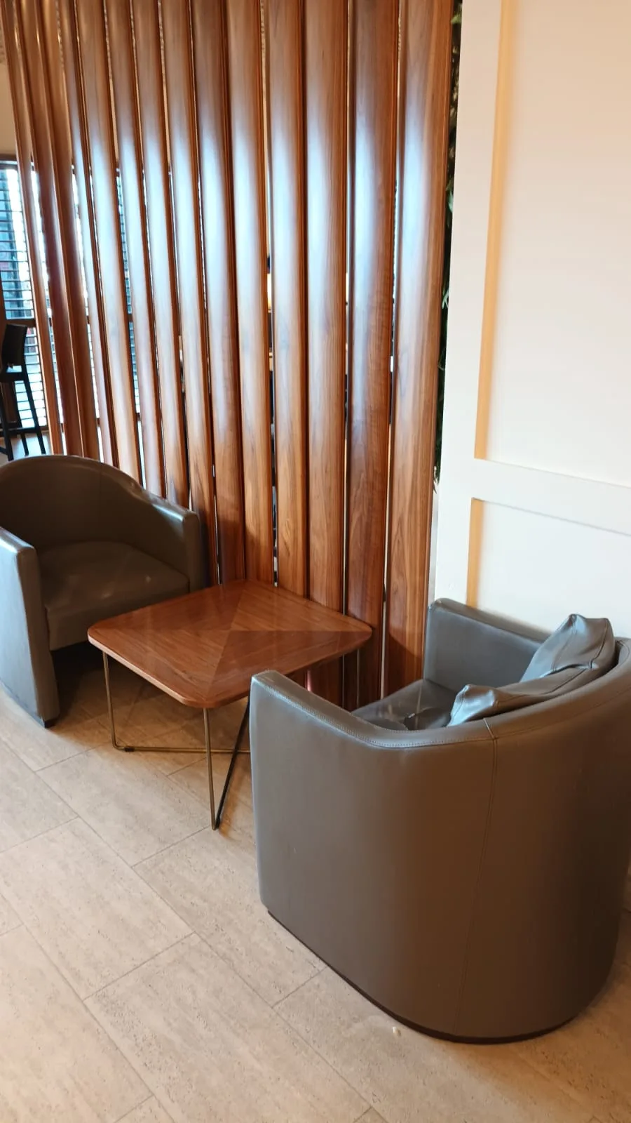 Lounge mit Sesseln und Tisch vor Holzvertäfelung