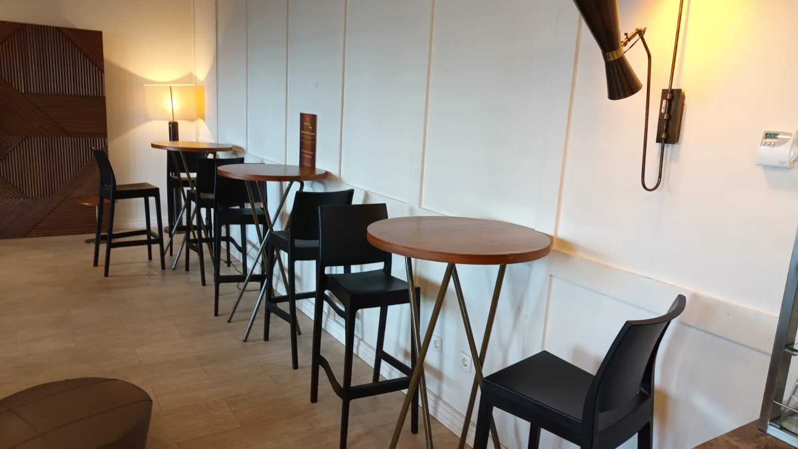 Lounge mit runden Tischen und schwarzen Stühlen