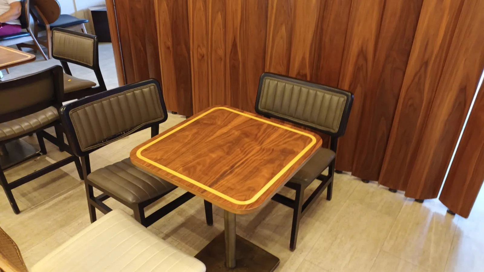 Holztisch mit gepolsterten Stühlen in einem Lounge-Bereich