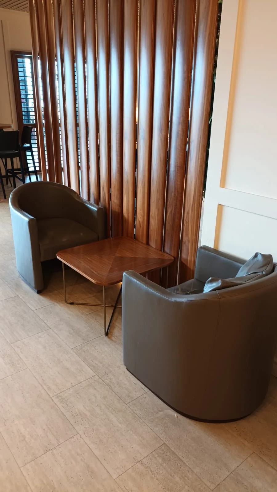 Zwei Sessel und ein Tisch vor Holzvertäfelung