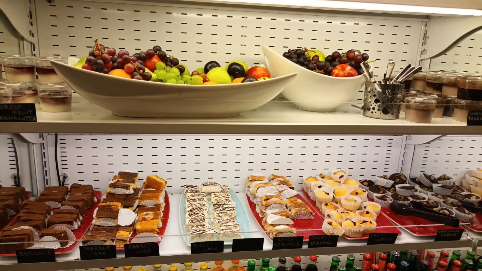 Fruchtschalen mit Obst und Kuchen auf Regal in Lounge