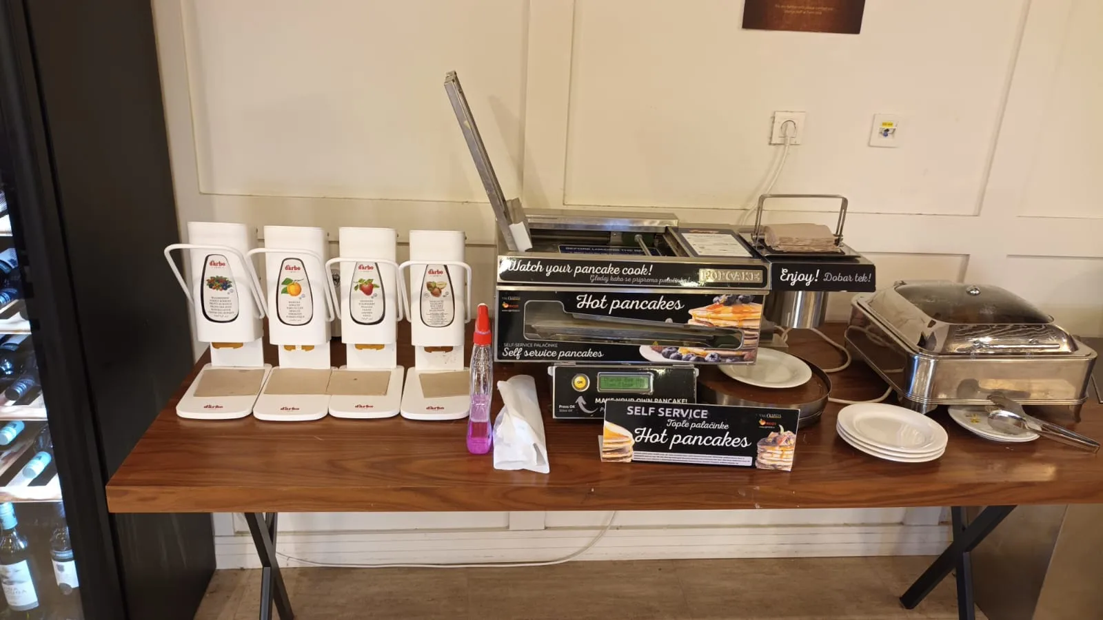Selbstbedienungsstation für Pancakes mit Pfannen und Zuckergussflasche