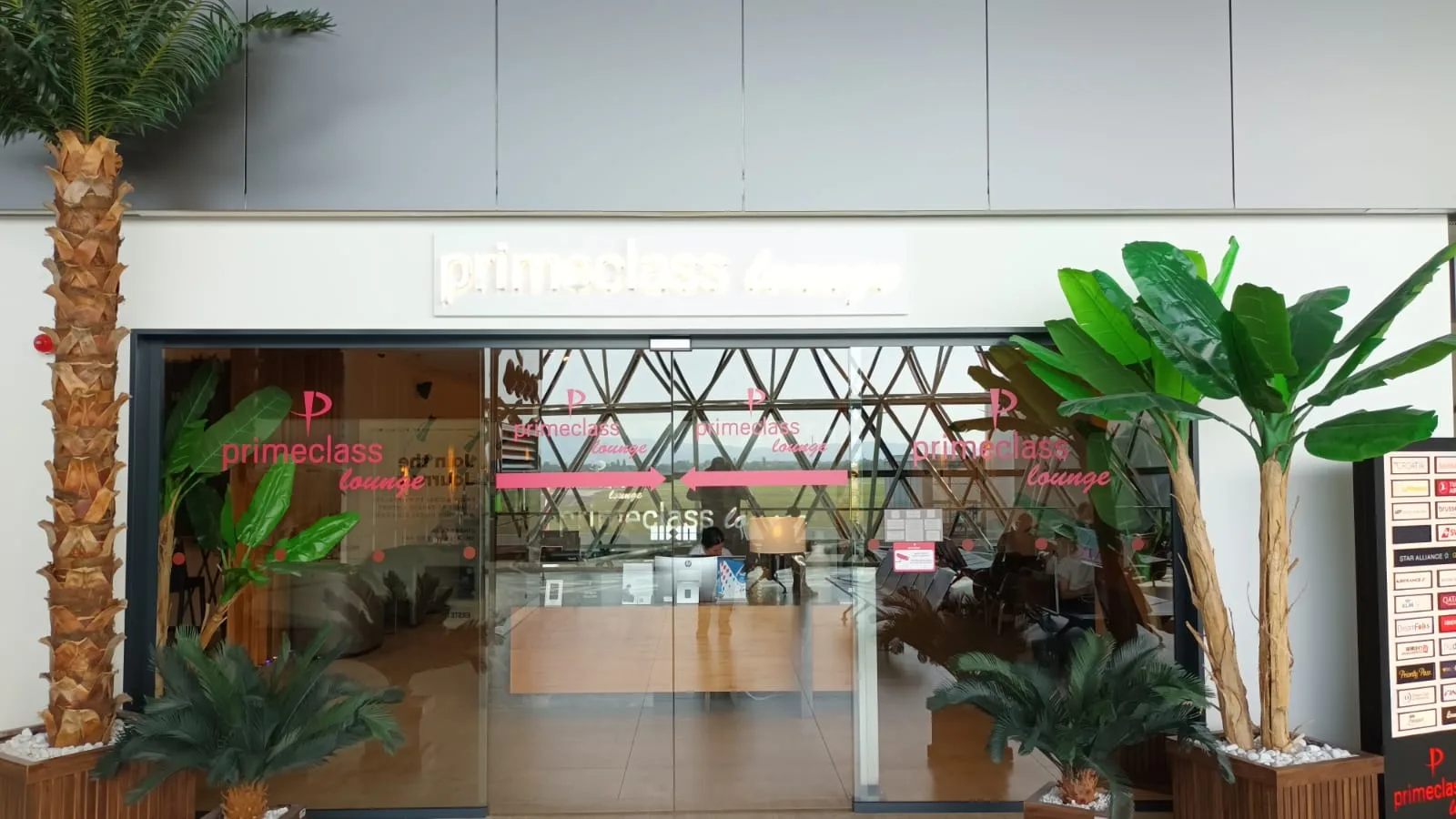 Primeclass Lounge Eingang mit Pflanzen und Schildern