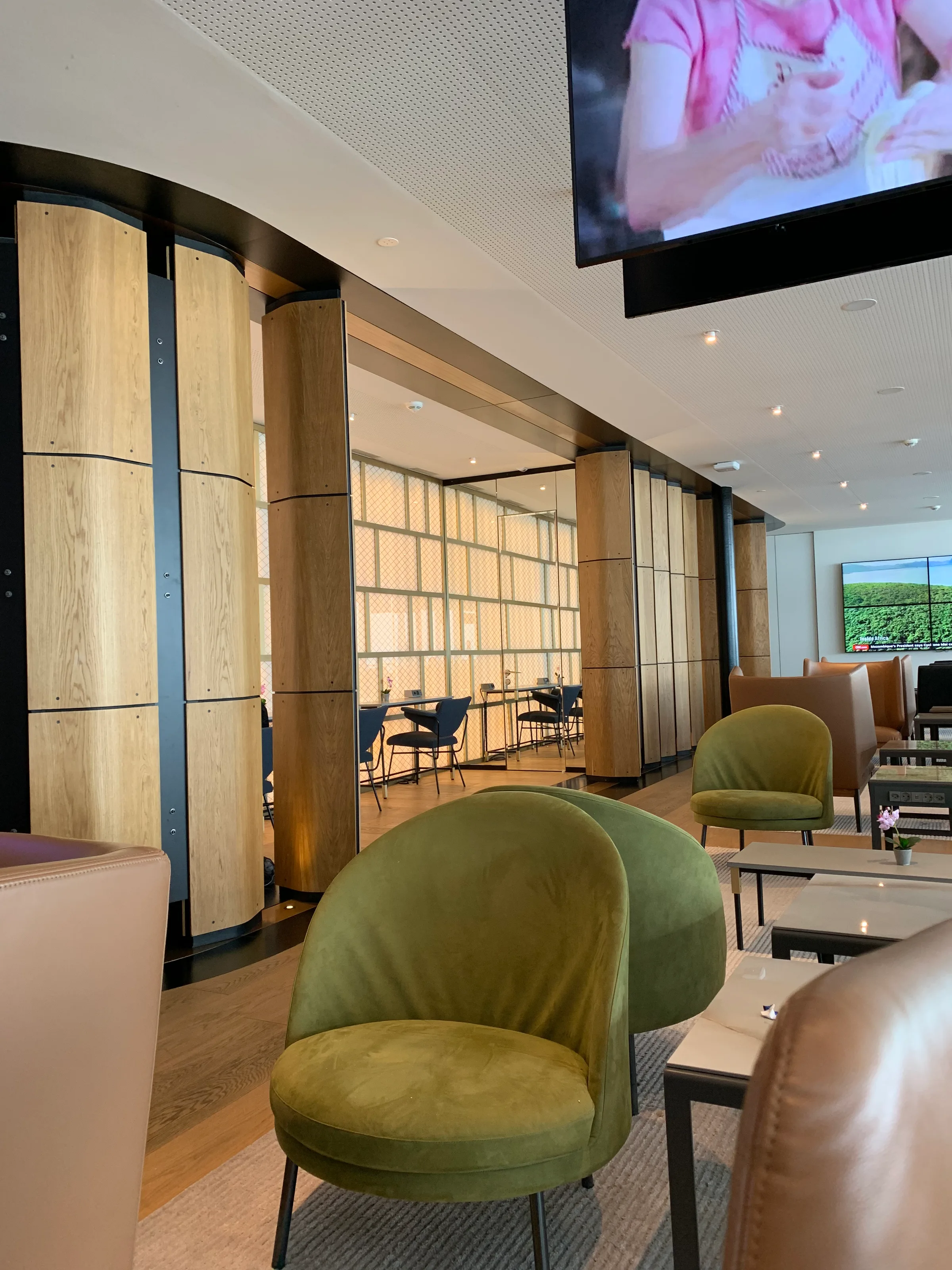 Lounge mit grünen Sesseln und Holzpaneelen