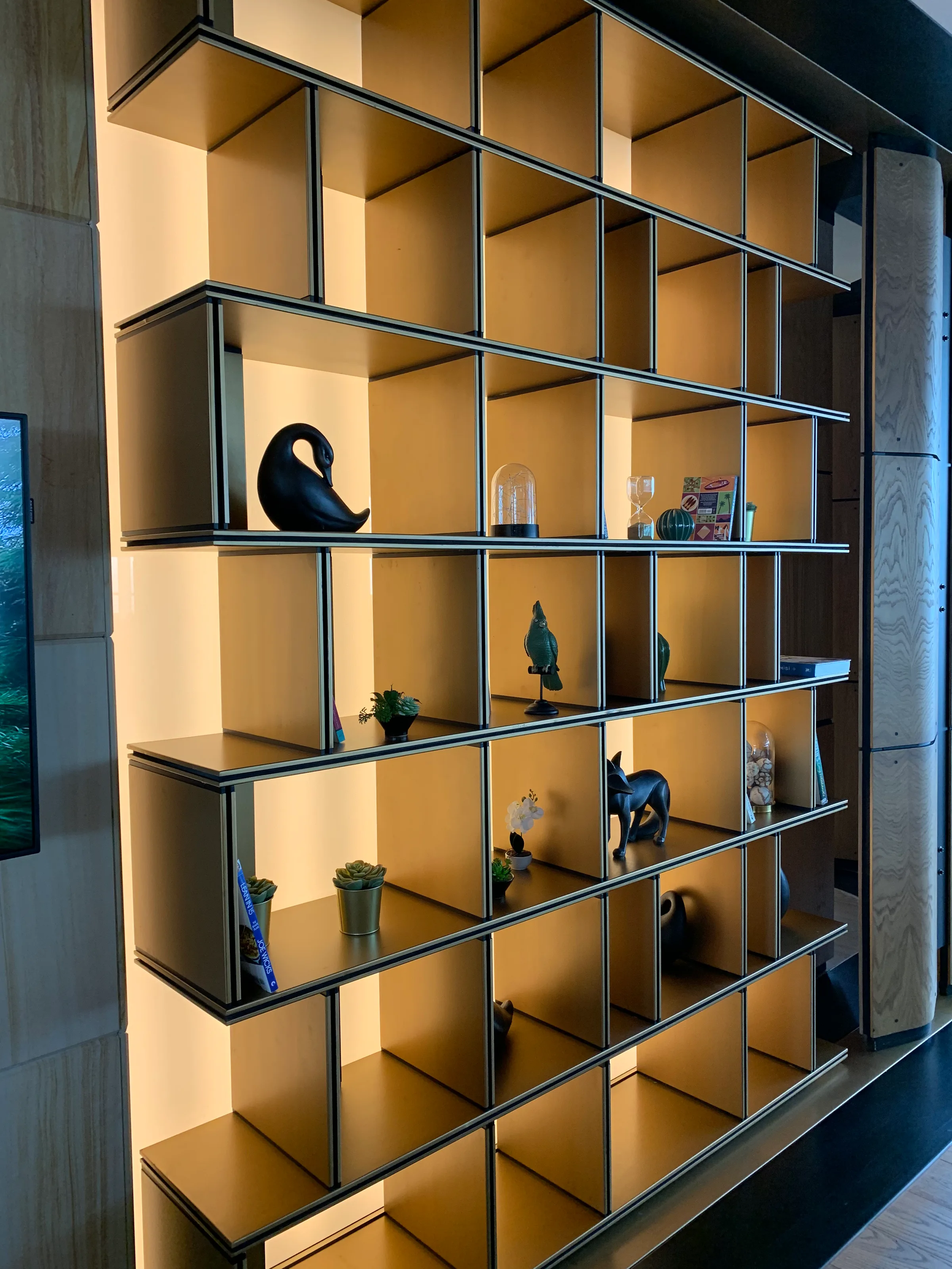 Moderner Regal mit dekorativen Gegenständen in einem Loungebereich