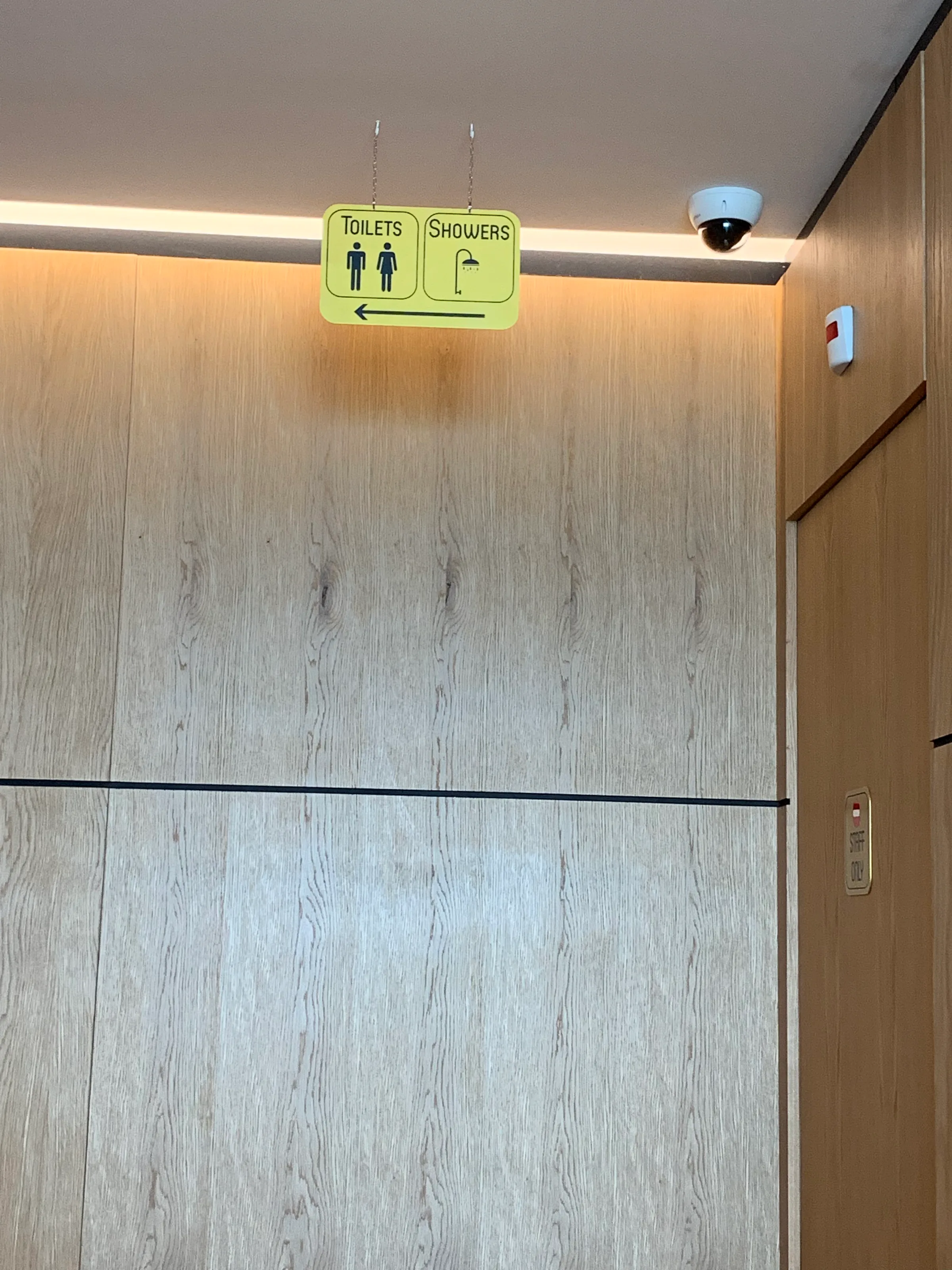 Badezimmer mit Hinweisschild für Toiletten und Duschen