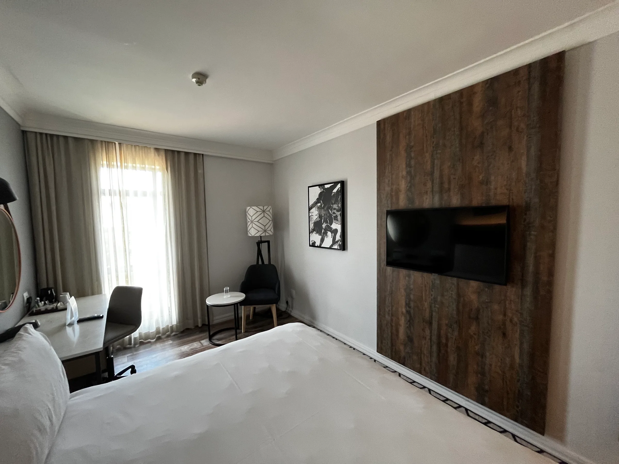 Hotelzimmer mit Doppelbett und Holzwand im Hintergrund