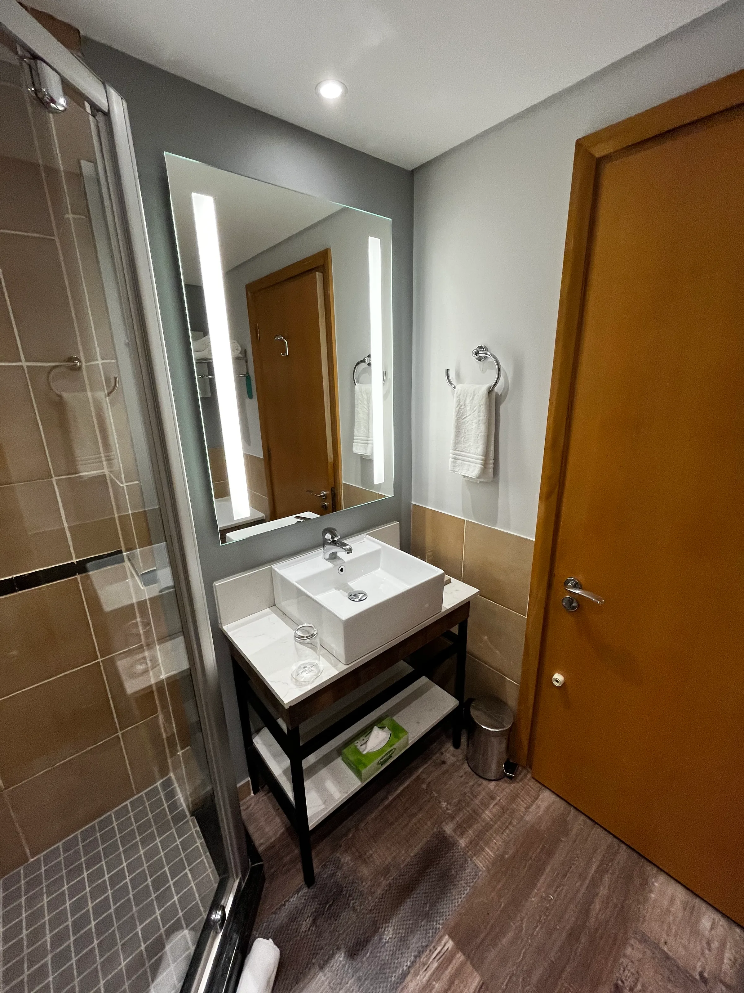 Moderatesize Hotelbad mit Waschbecken, Spiegel und Handtuchhalter