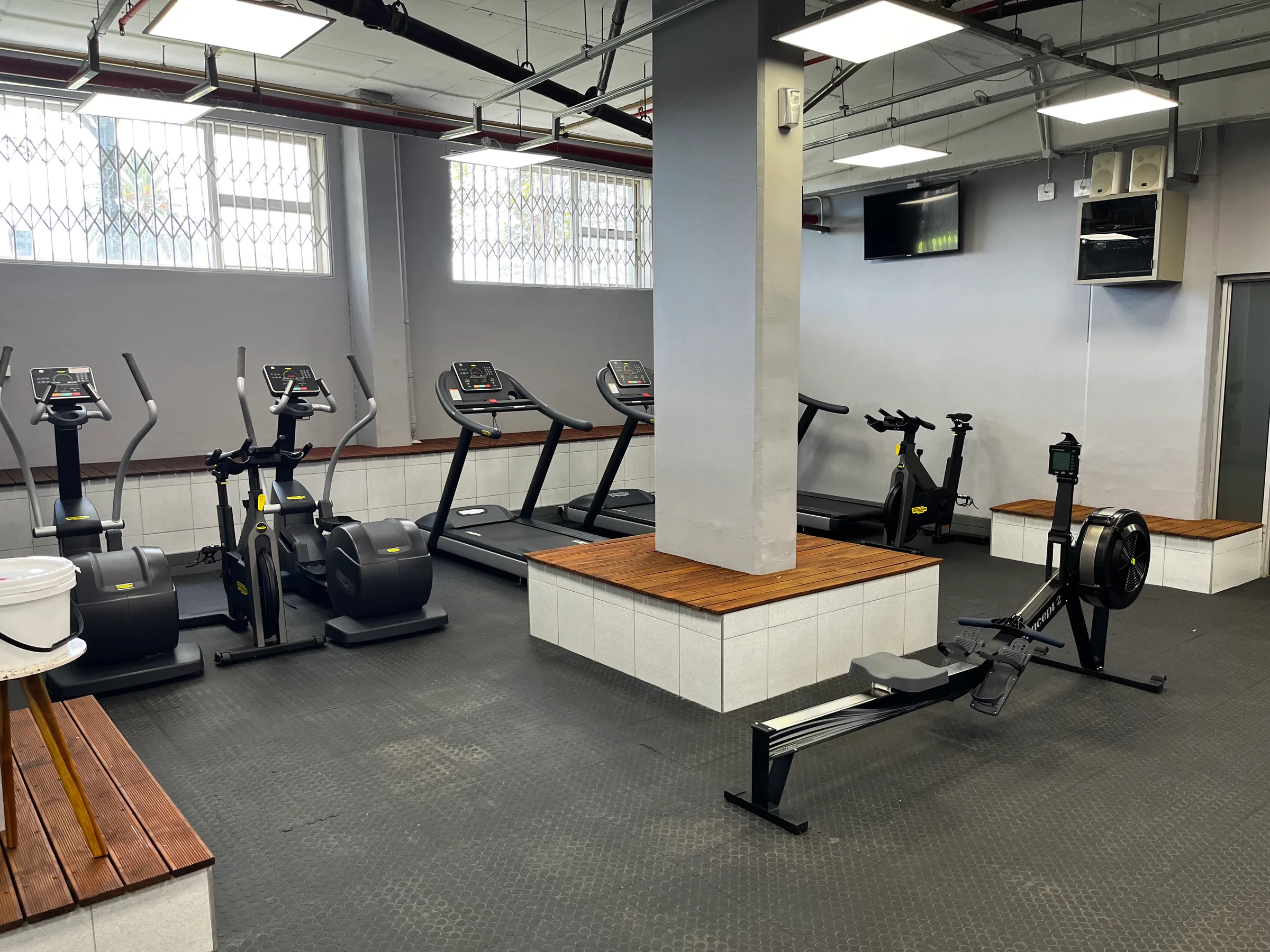 Fitnessraum mit Laufbändern, Rudergeräten und Elliptikern