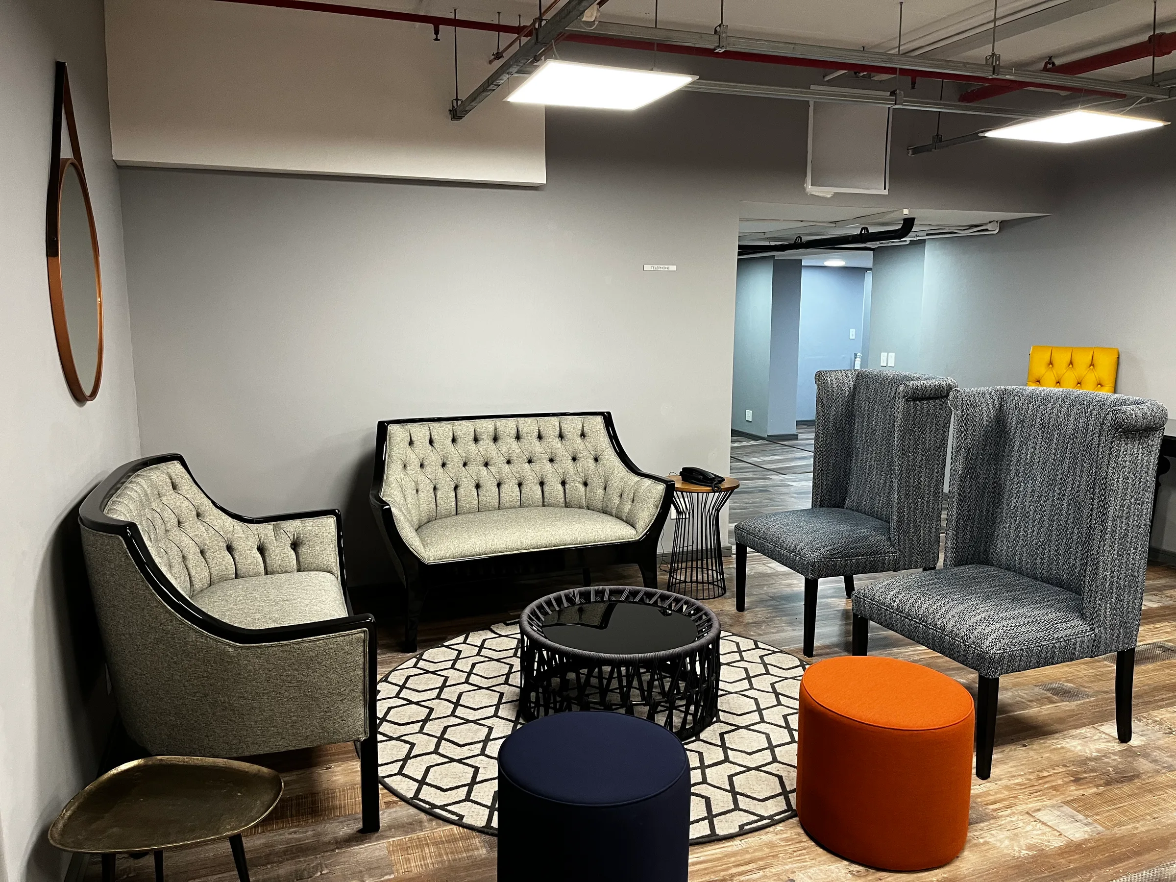 Hotellobby mit Sesseln und Couch in Grautönen