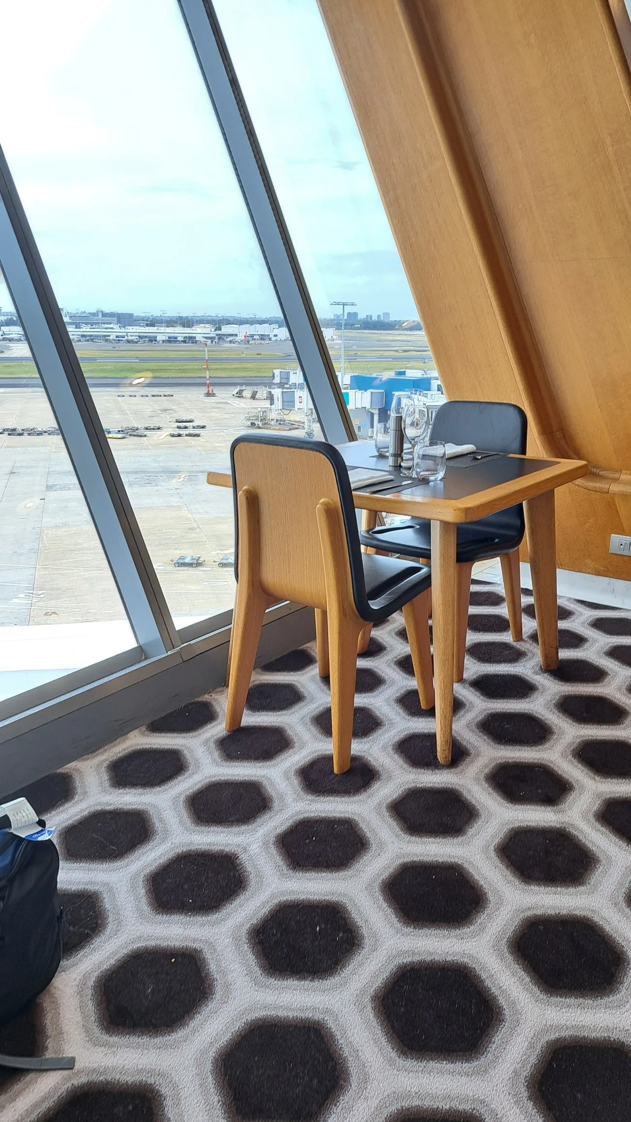 Tisch und Stühle im First Lounge mit Blick auf Flughafen