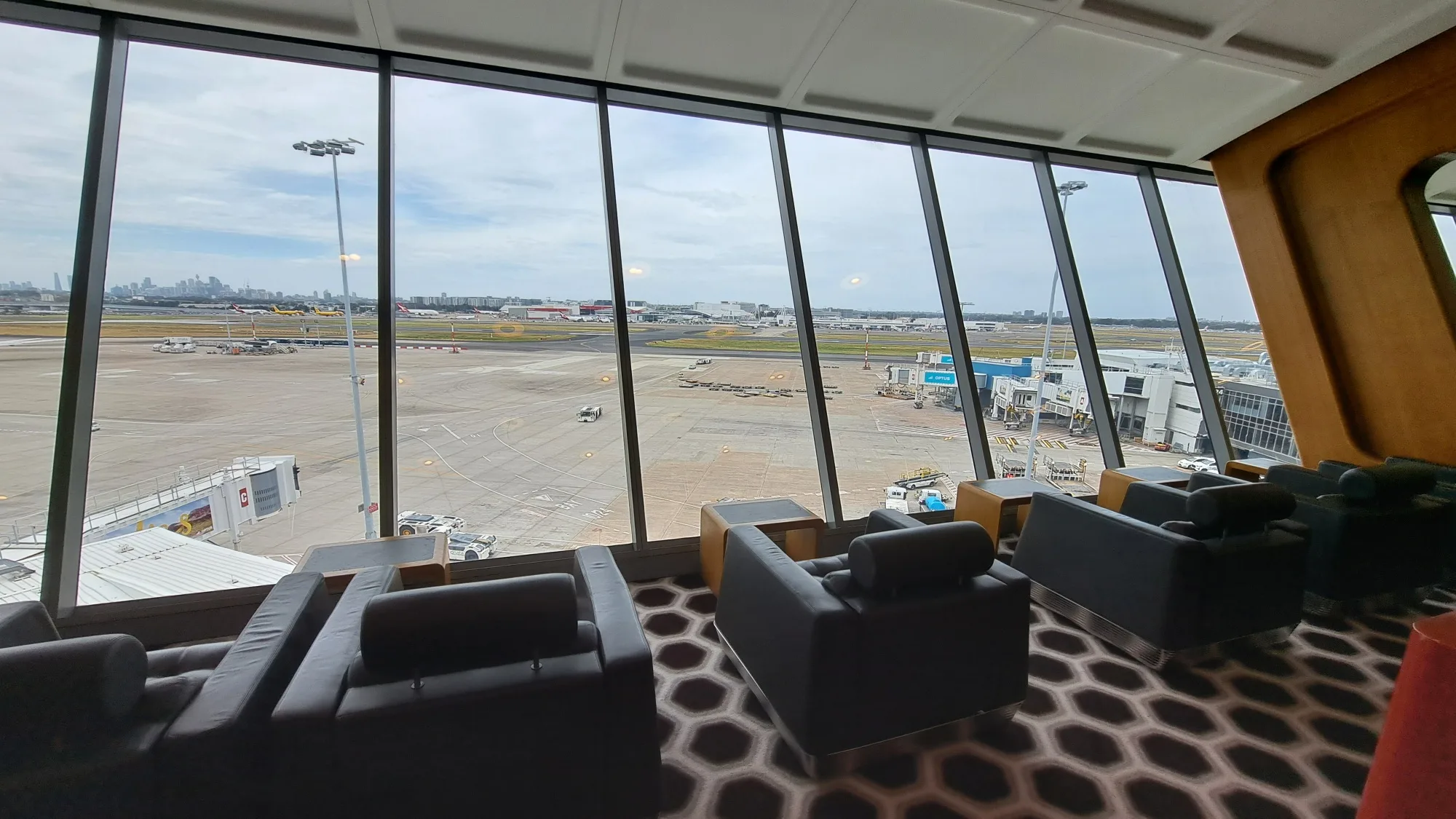 Lounge mit Sesseln und Panoramafenstern auf Flughafen