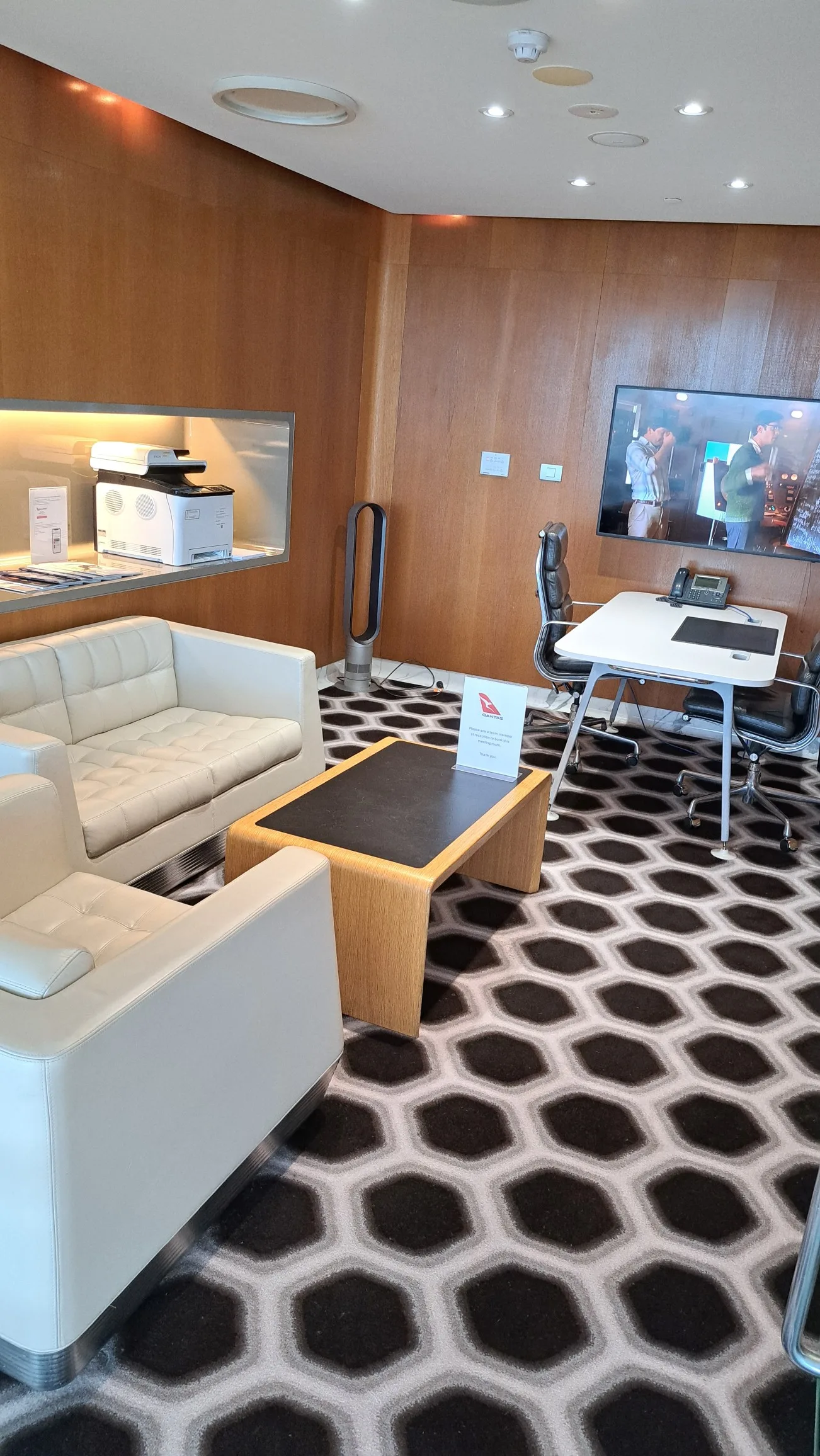 Erholungsraum mit Sesseln, Couch und Fernseher im Flughafenlounge