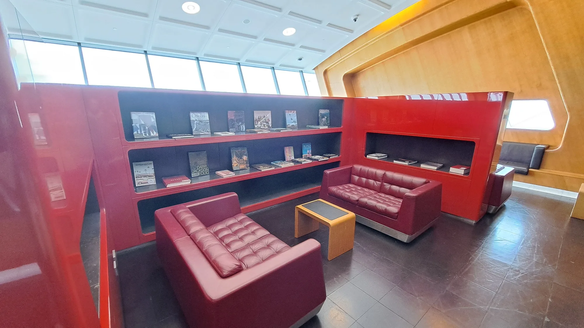 Rote Lesecke mit Büchern und Sesseln im Flughafenlounge