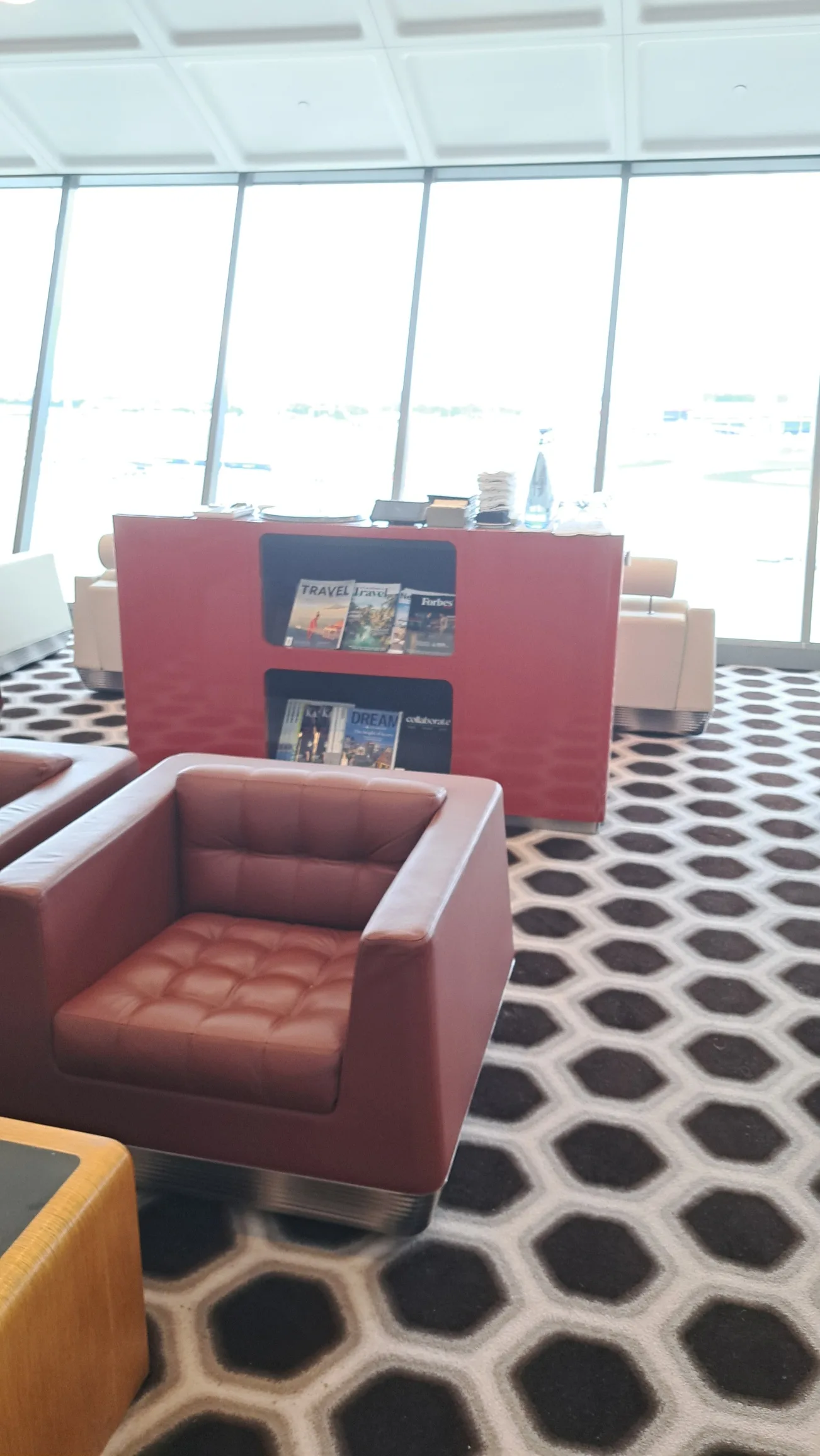 Rotbraune Ledersessel in einem Loungesaal mit großem Fenster