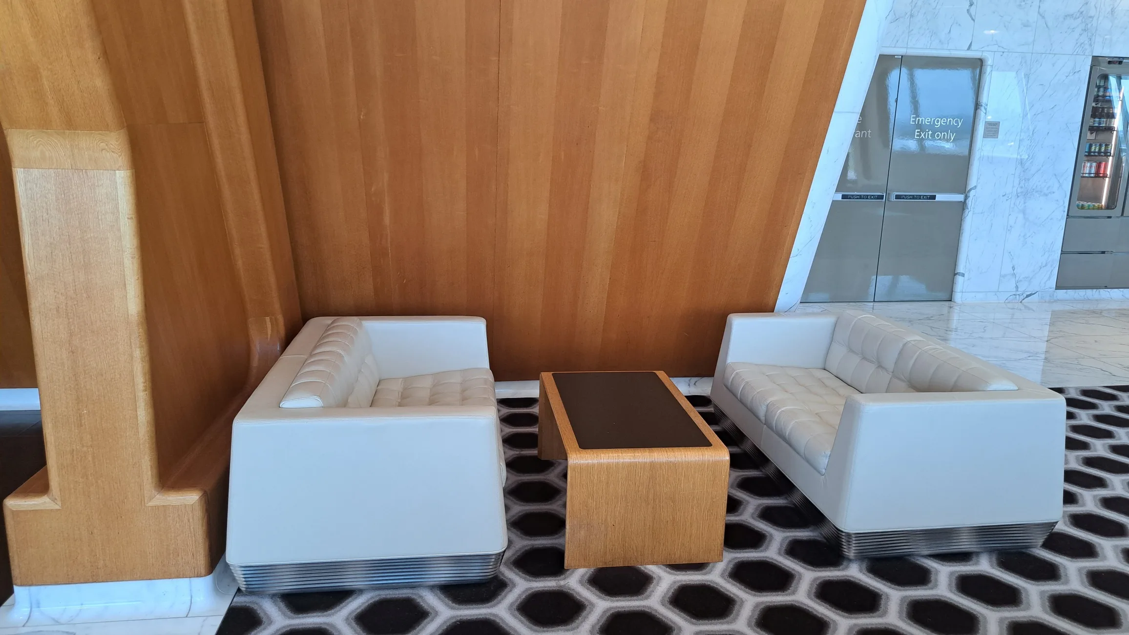 Weißer Sessel und Couch vor Holzwand im Flughafenlounge