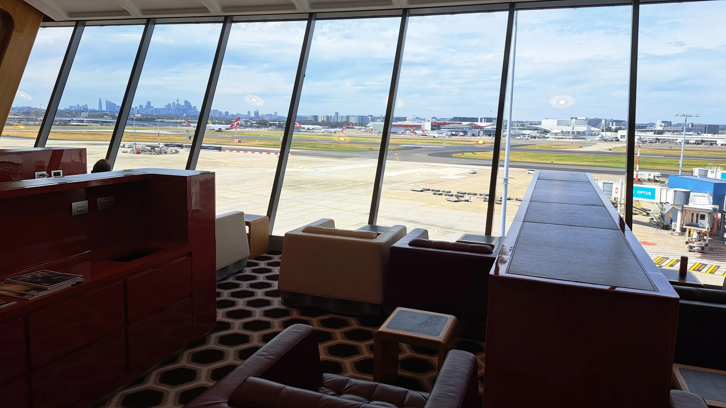 Qantas First Lounge mit Blick auf Flughafen und Stadt