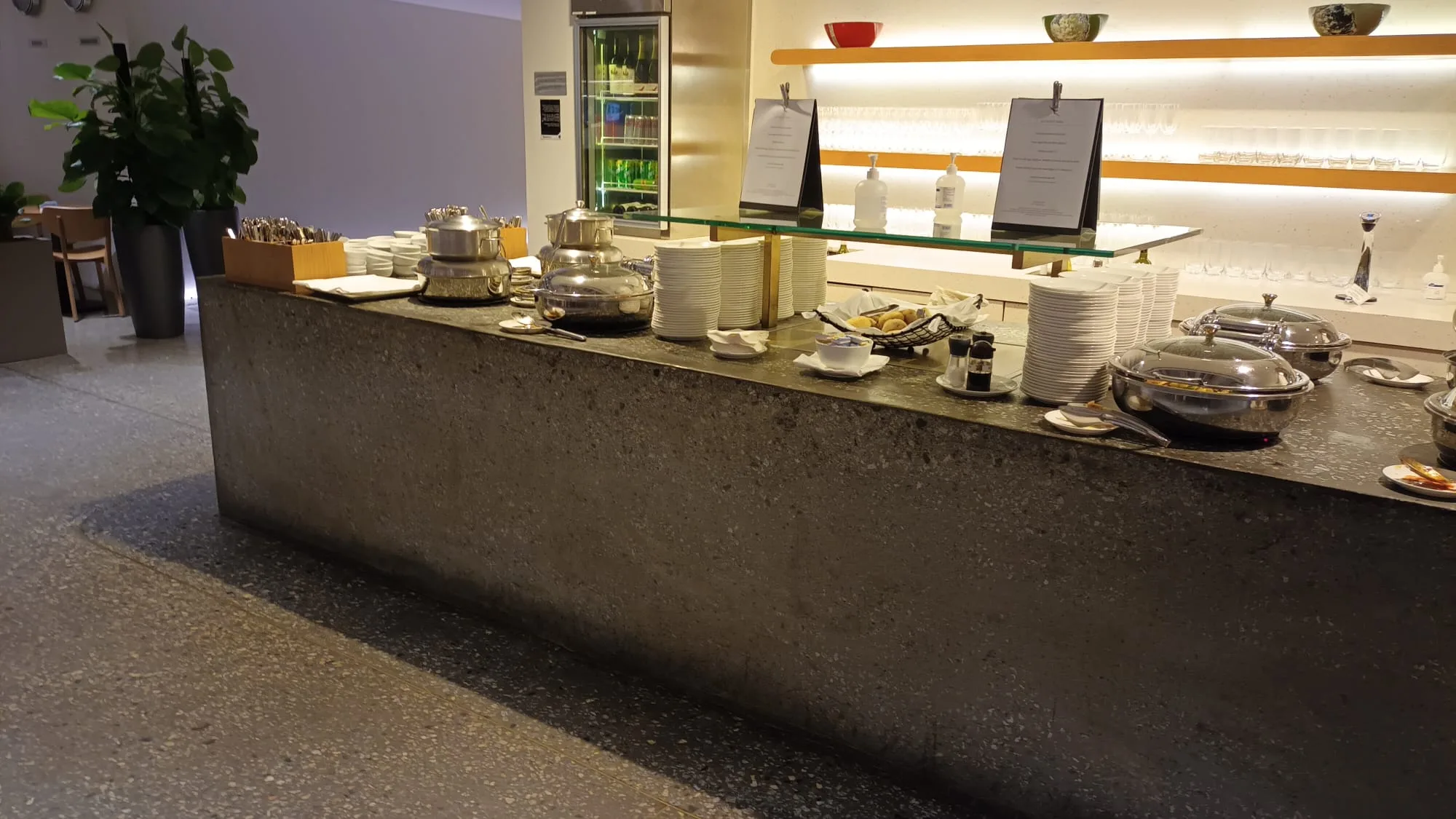 Buffet-Tisch mit Geschirr und Kochutensilien im Flughafenlounge