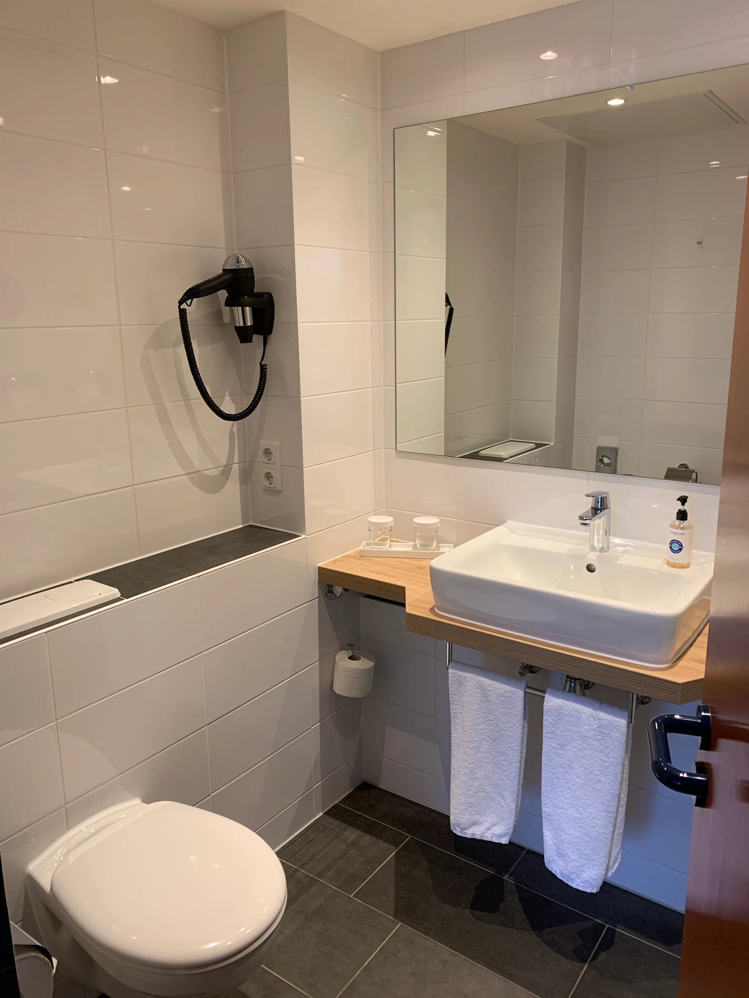Moderatesize Hotelbad mit Toilette, Waschbecken und Spiegel