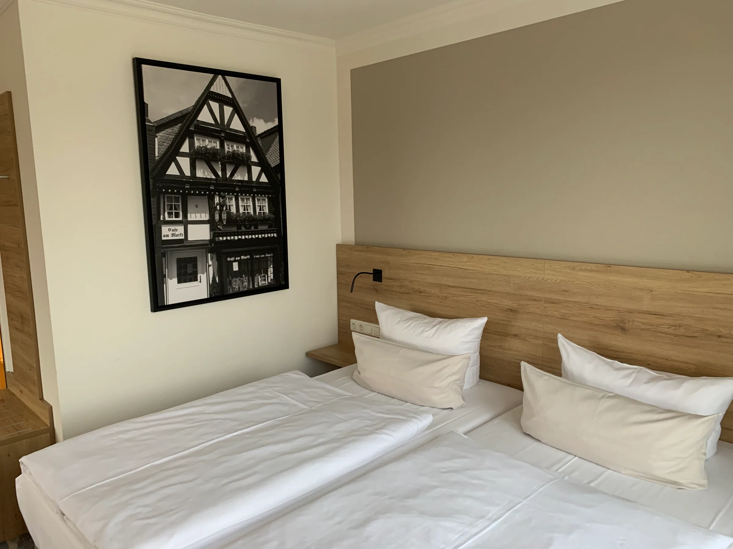 Hotelzimmer mit Doppelbett und Holzbettgestell