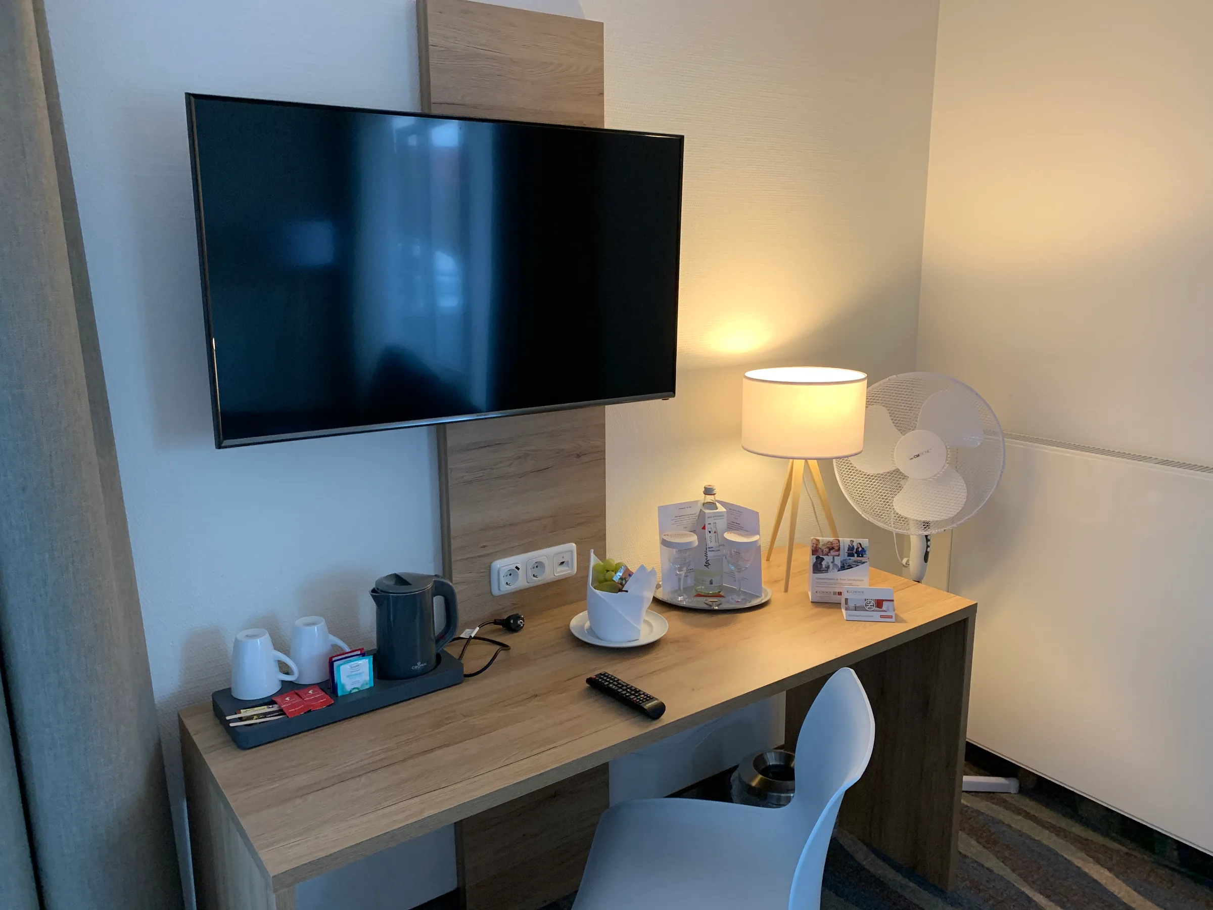 Hotelzimmer mit Schreibtisch, Fernseher und Lampen