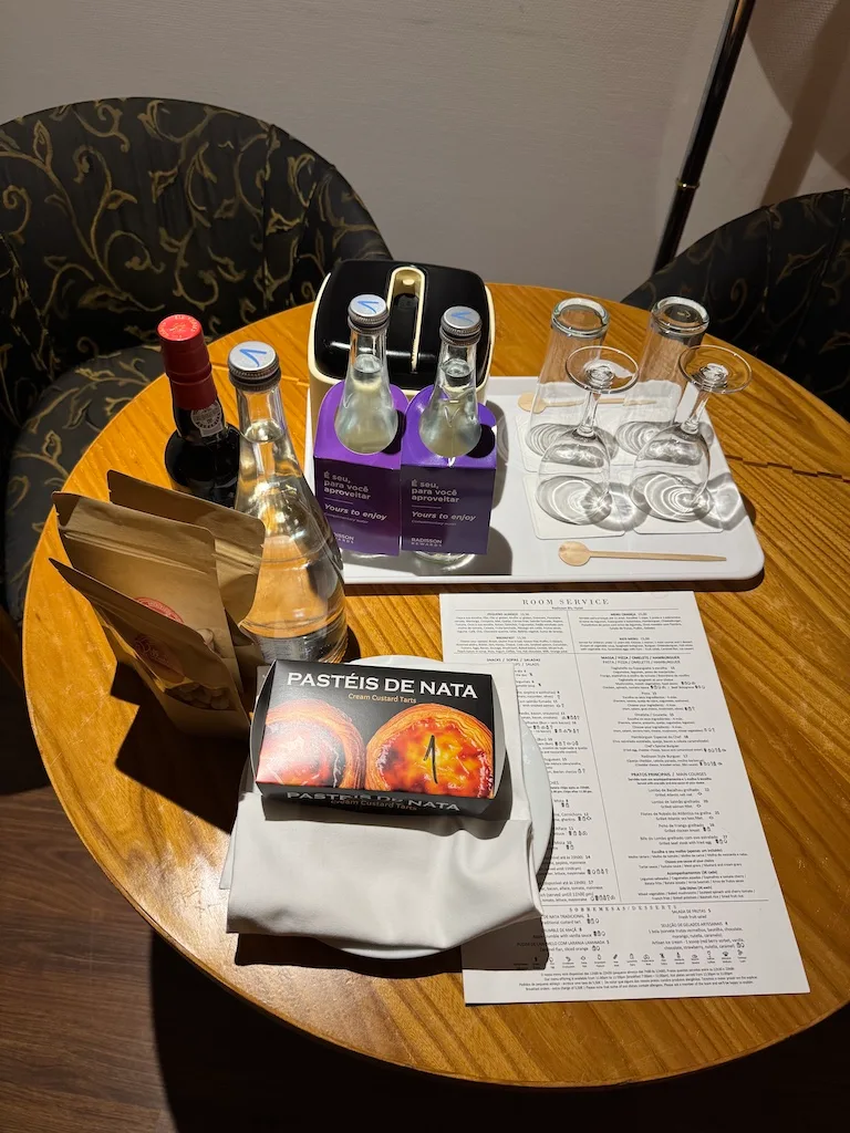 Hotelzimmertisch mit Pastéis de Nata und Getränken