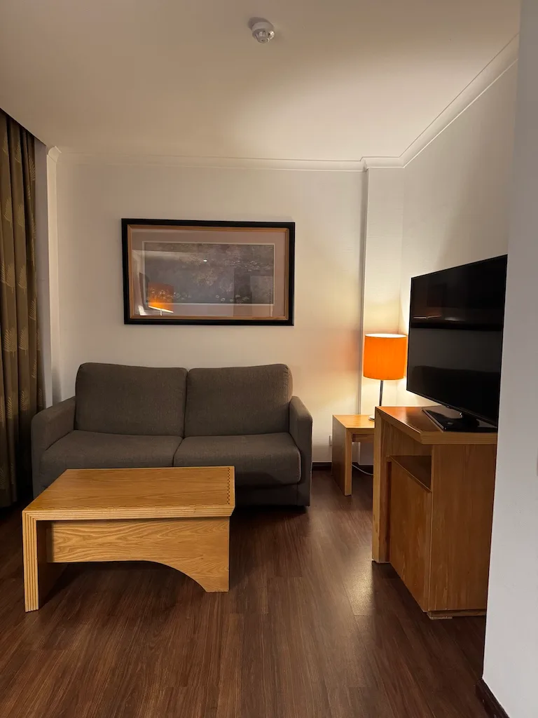 Hotelzimmer mit Couch, Tisch und Fernseher