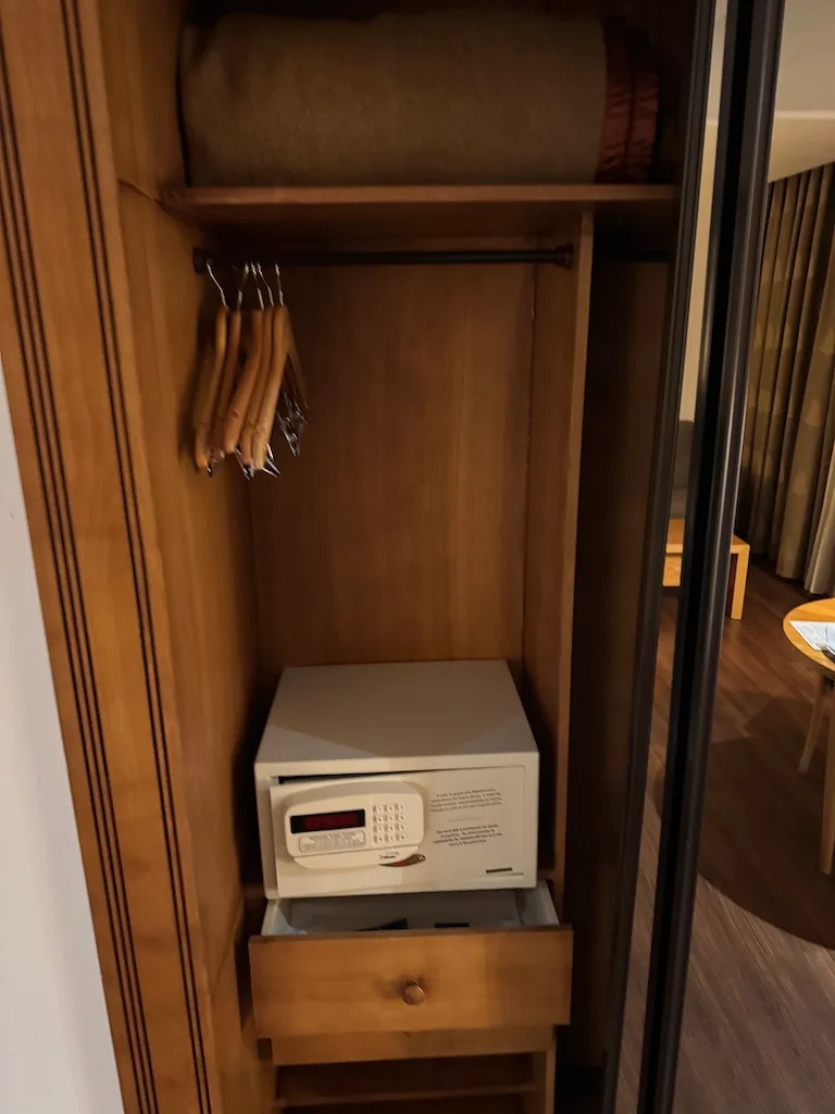 Holzschrank mit Kleiderbügeln, Schublade und Safe im Hotelzimmer