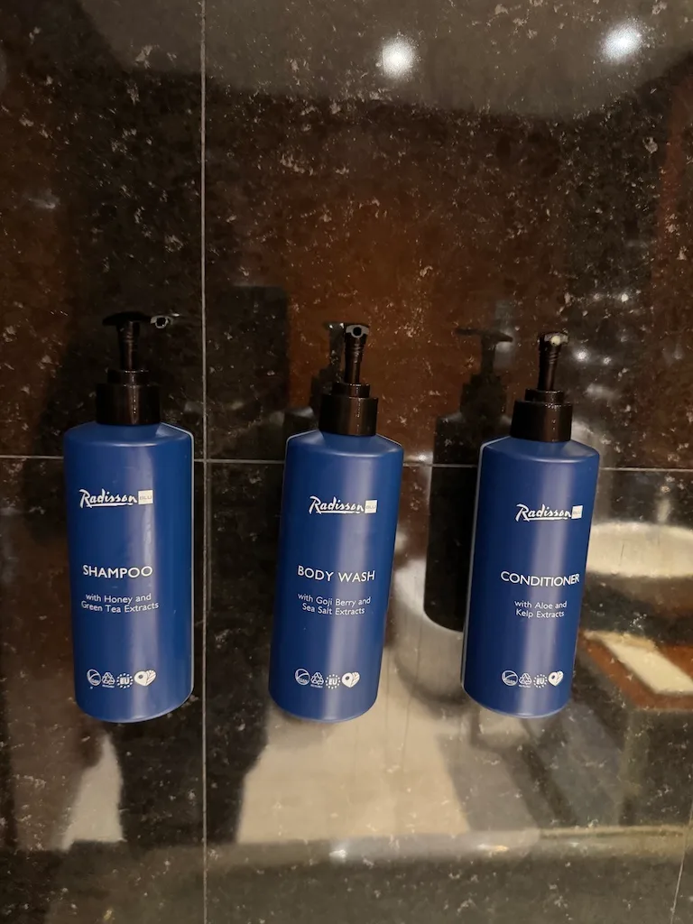 Drei Flaschen mit Shampoo, Body Wash und Conditioner von Radisson