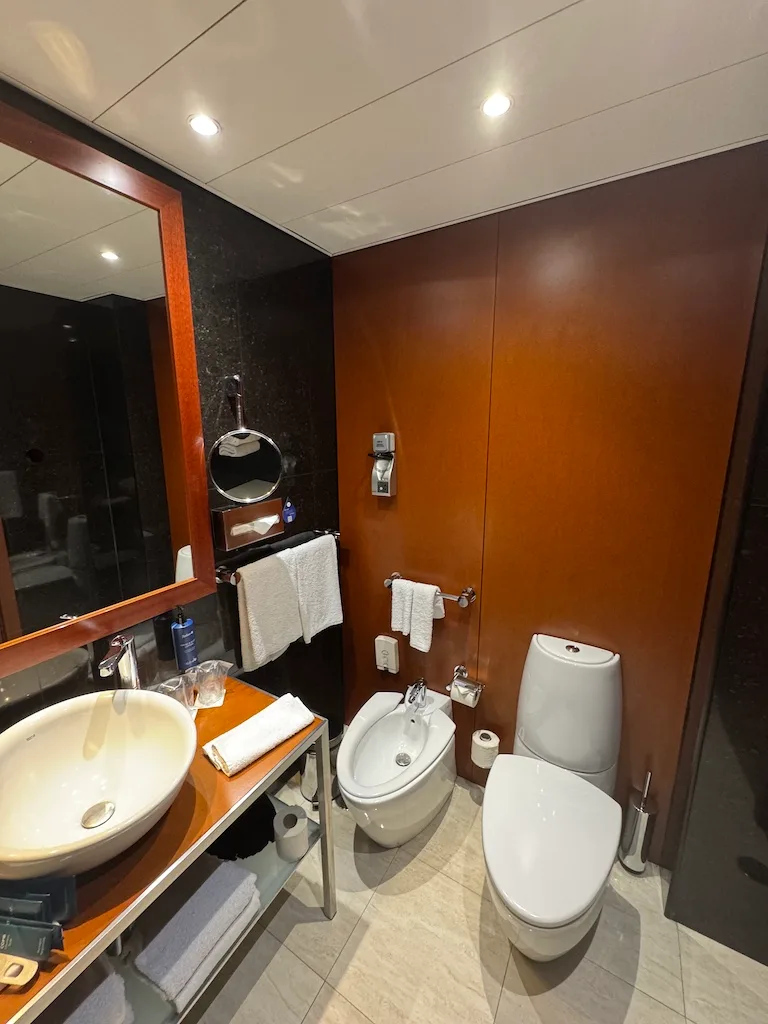 Moderatesize Hotelbad mit Waschbecken, Spiegel und Bidet
